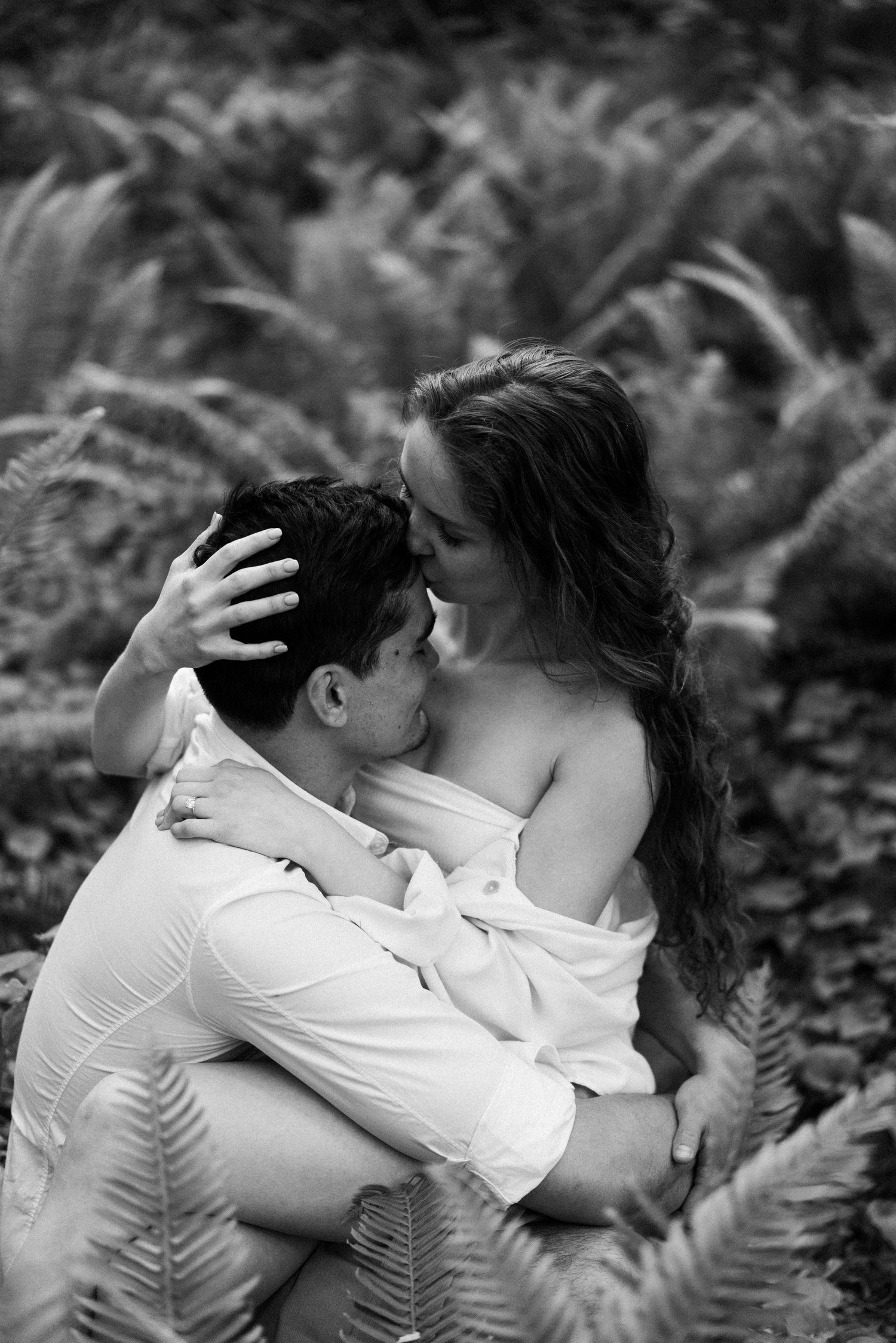 Black and white romantic portrait among ferns in nature.