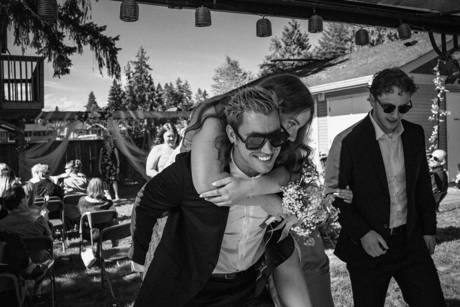 Black and white photo collage showing candid moments at an outdoor wedding celebration with dancing and festivities.