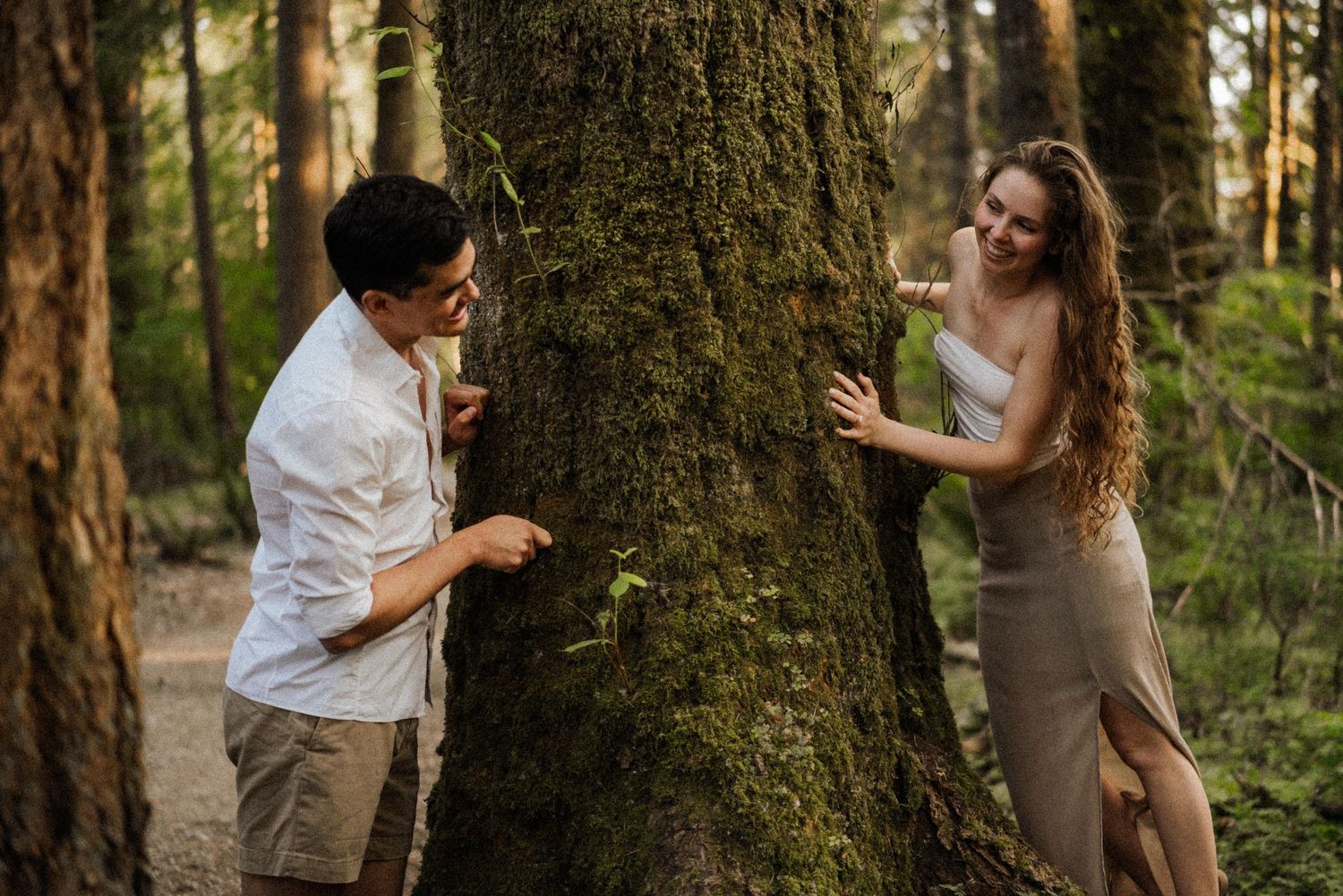 A romantic forest photoshoot with couples posing by mossy trees.