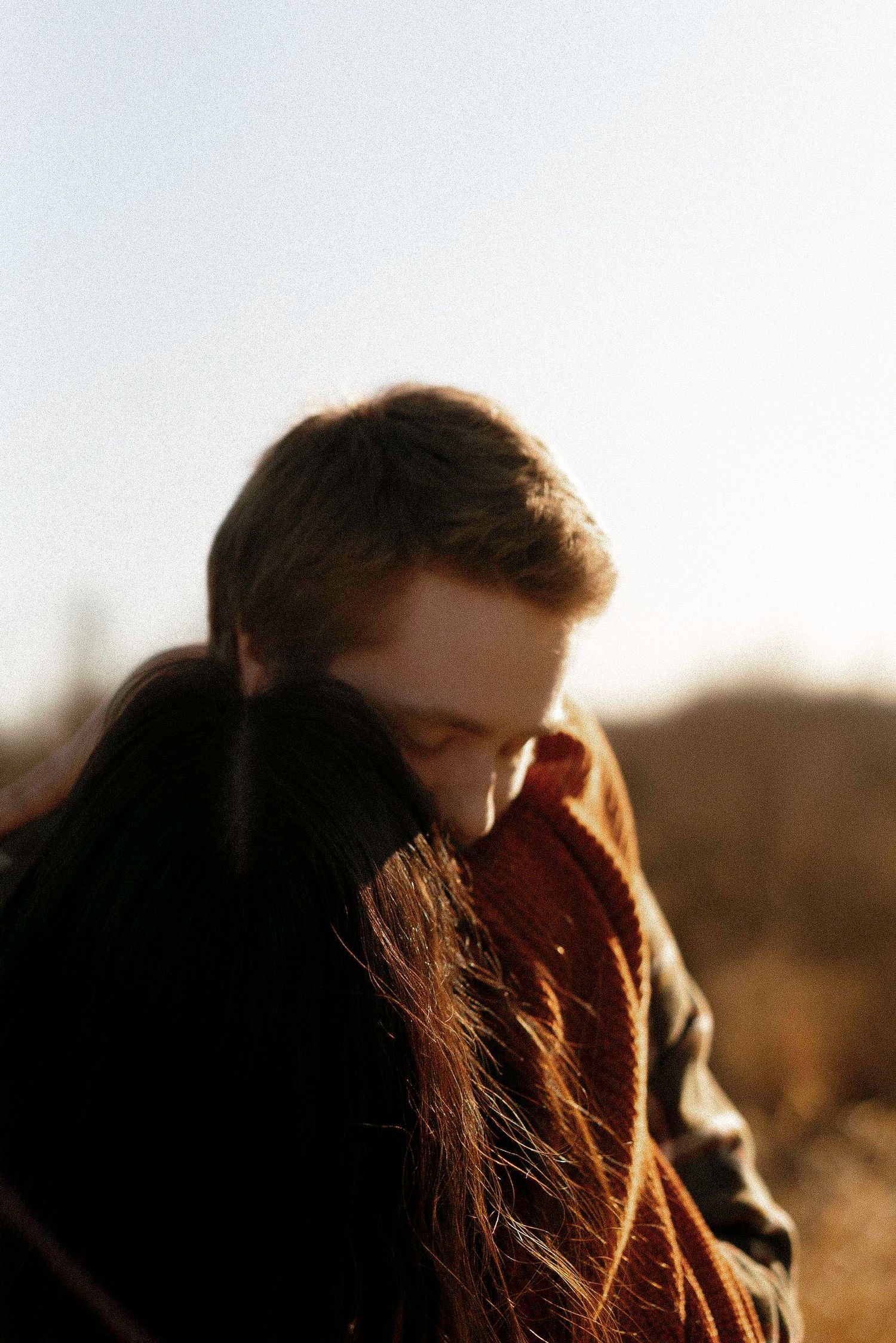 Warm sunlit silhouettes of a couple in an intimate moment during golden hour.