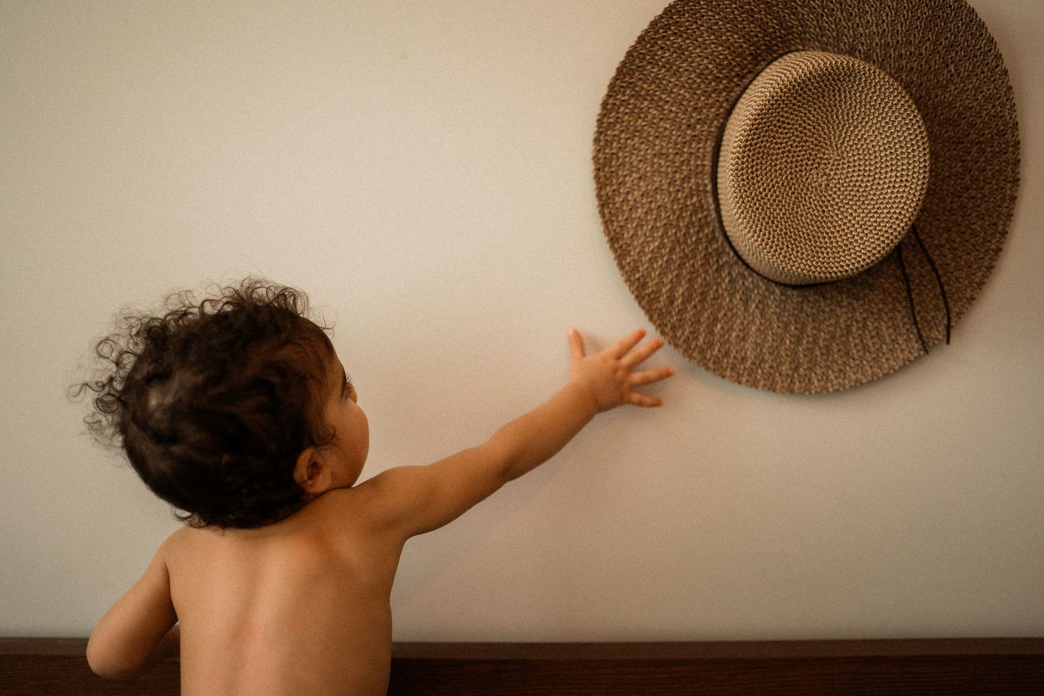 Series of artistic shots featuring someone with a brown straw hat against a neutral background.