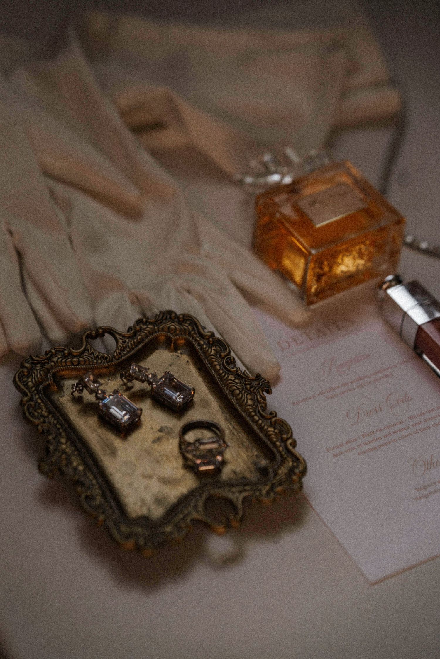 Vintage ornate frames and perfume bottles lay scattered on a desk.