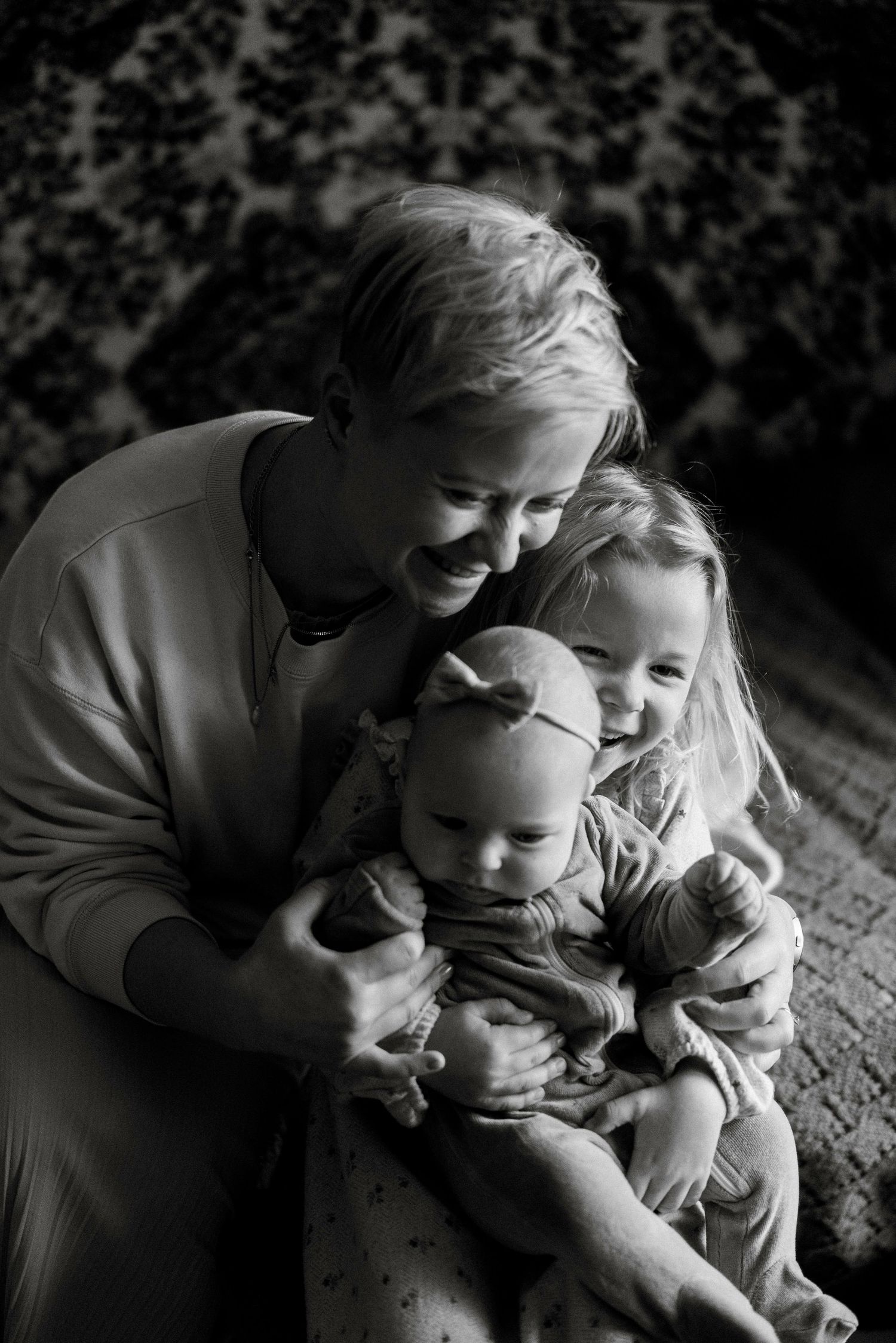 Intimate black and white portrait captures joyful family moment indoors.