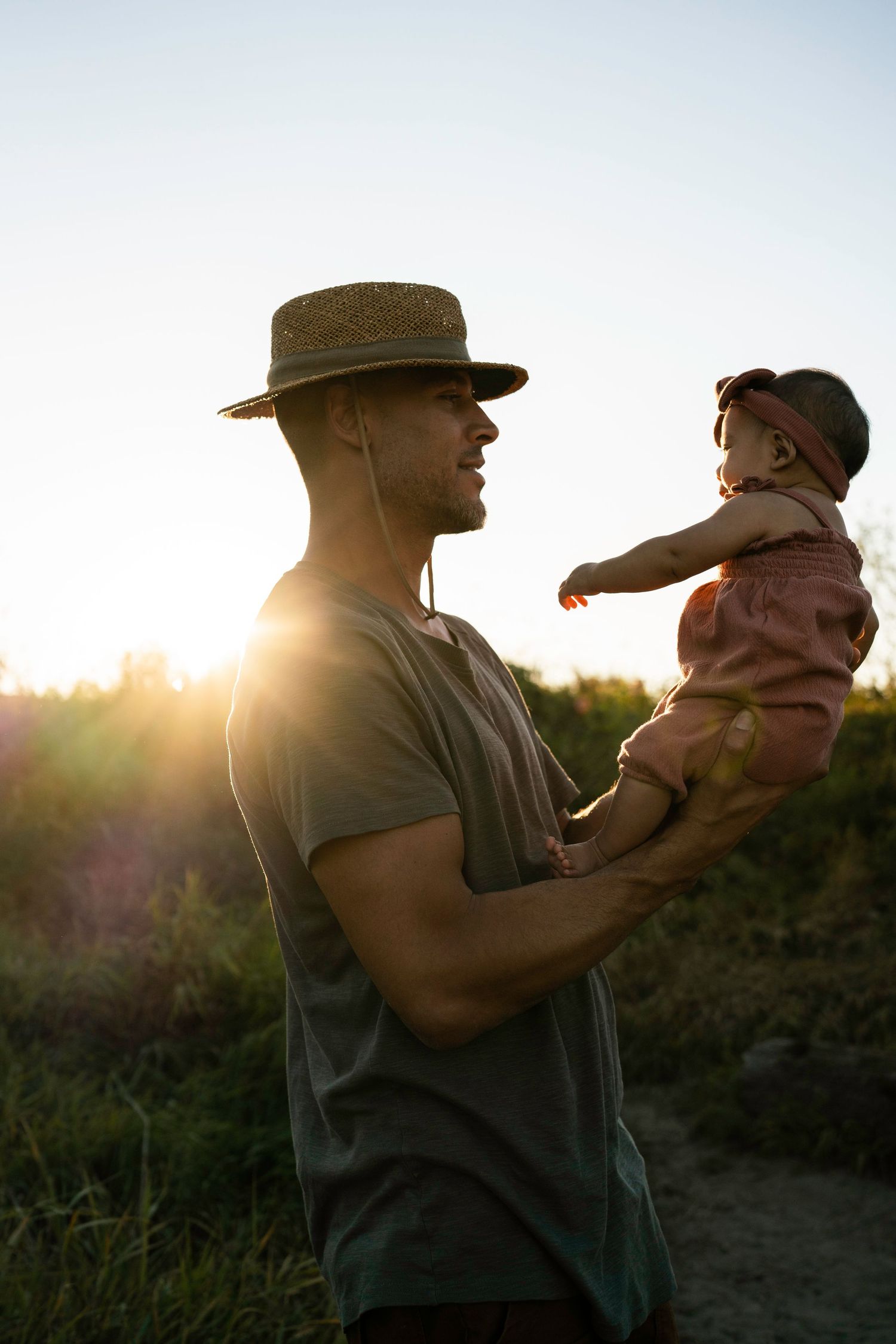 Silhouette of parent and child sharing tender moment at sunset.
