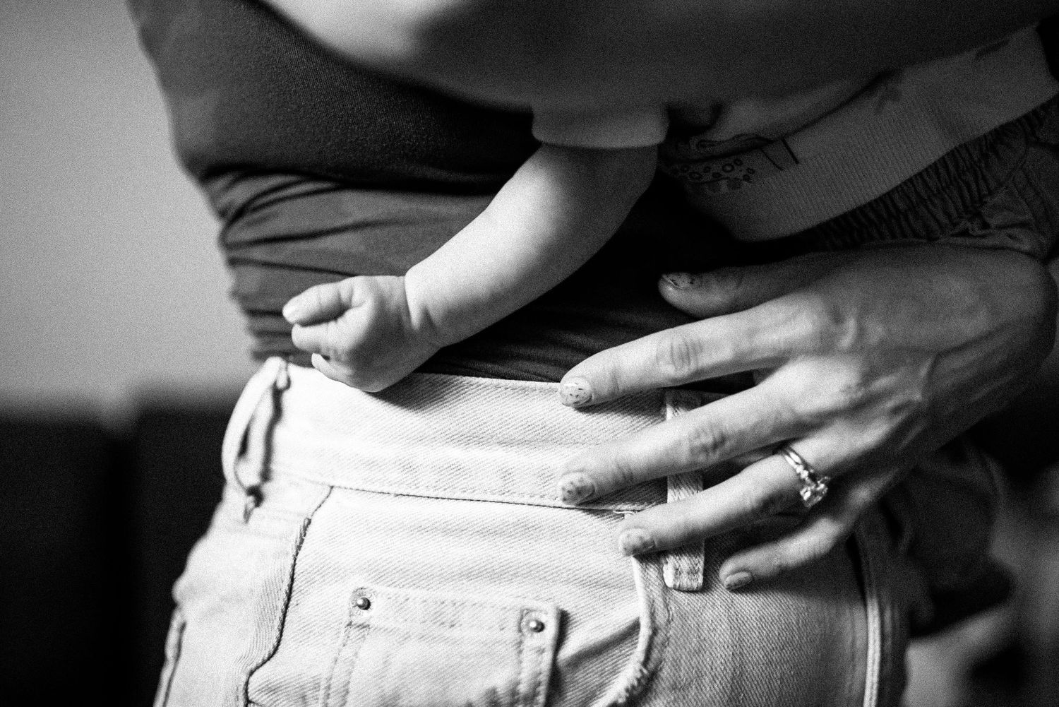 Close-up black and white photo sequence showing hands putting on white denim jeans.