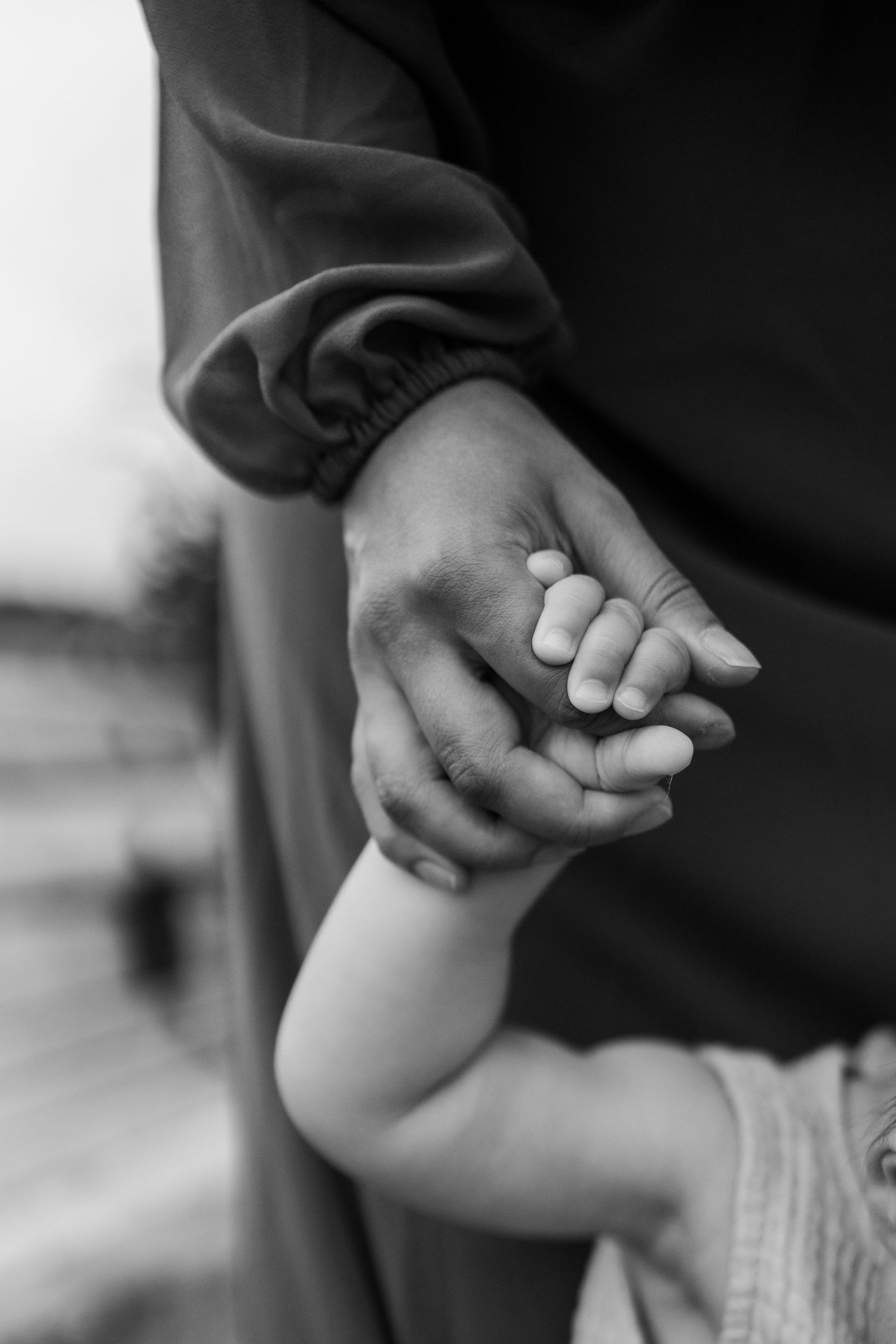 Close-up black and white image of holding hands showing tender connection.