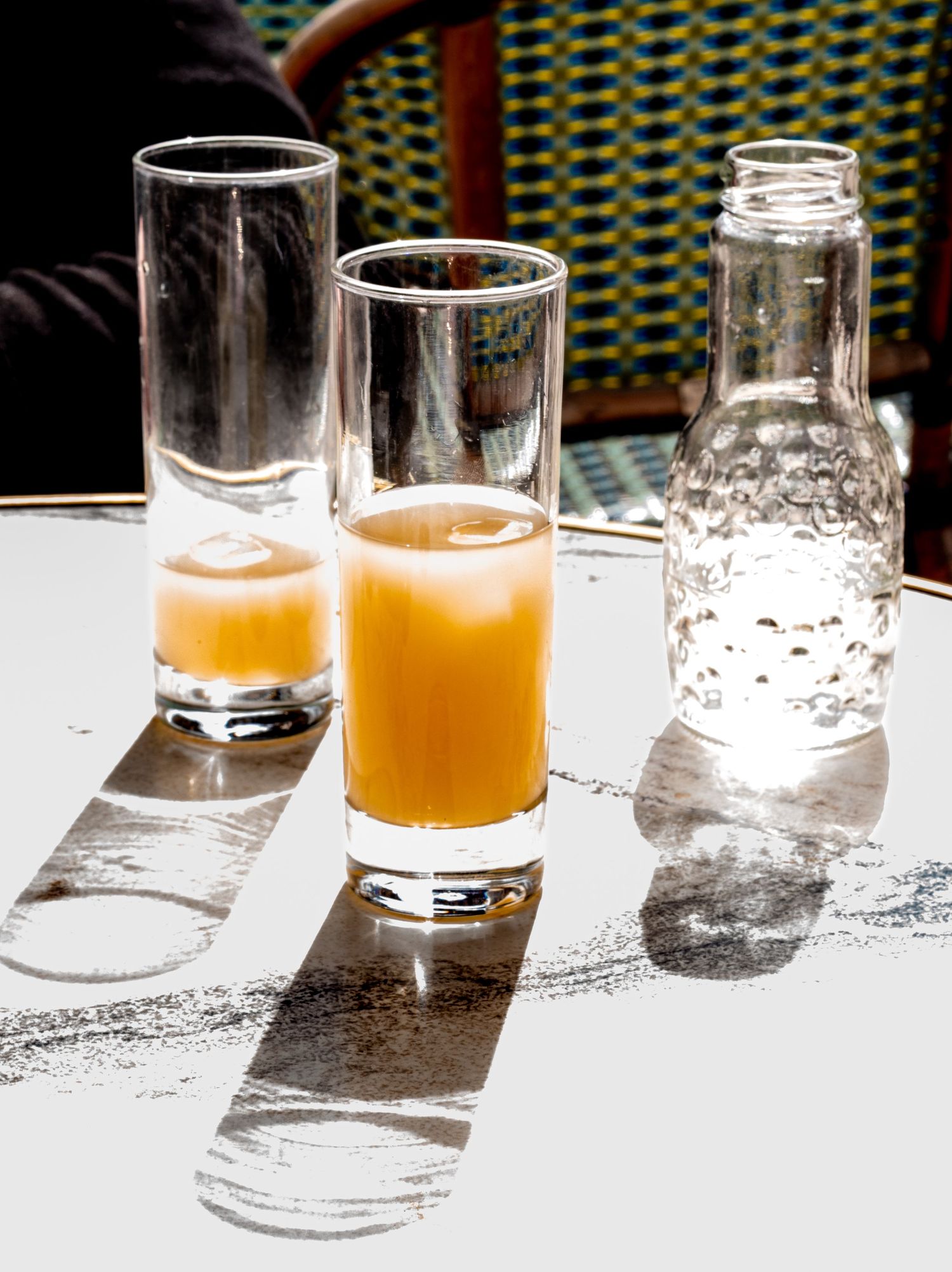 Ricard liquor drink in tall glasses beside a water bottle on a sun-drenched white table. France photographer montpellier