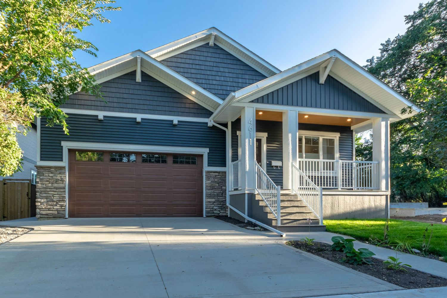 Central Alberta Real Estate Blue and white bungalow home with front double garage and front balcony David Spence Photography Media