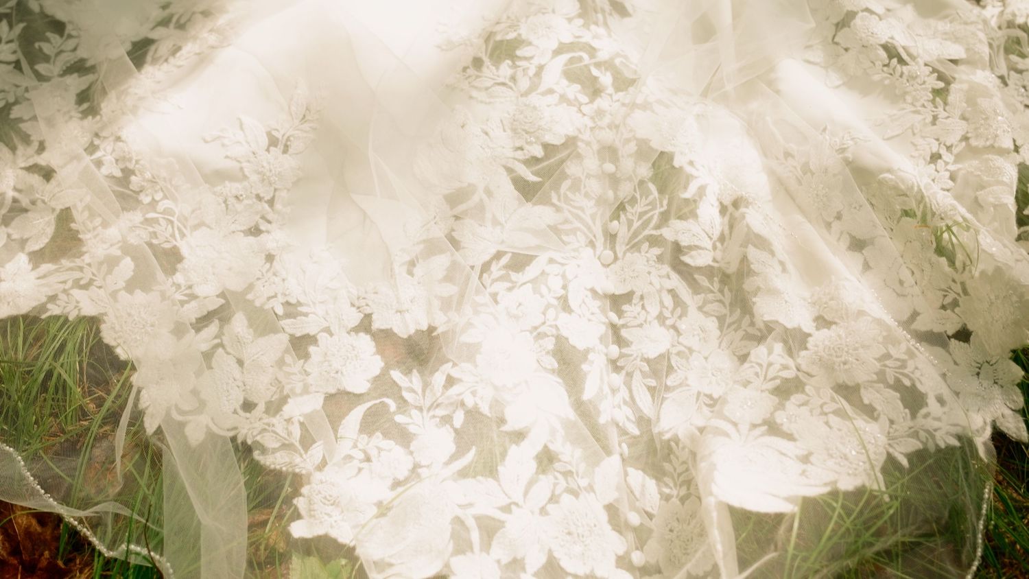 Close-up of intricate floral lace detailing on a white bridal wedding veil.