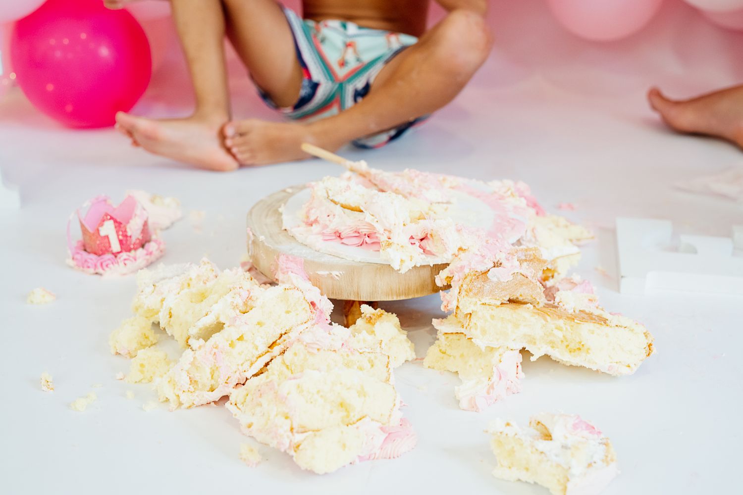 A close-up of pink and cream colored candy bark or chocolate pieces scattered on a white surface.