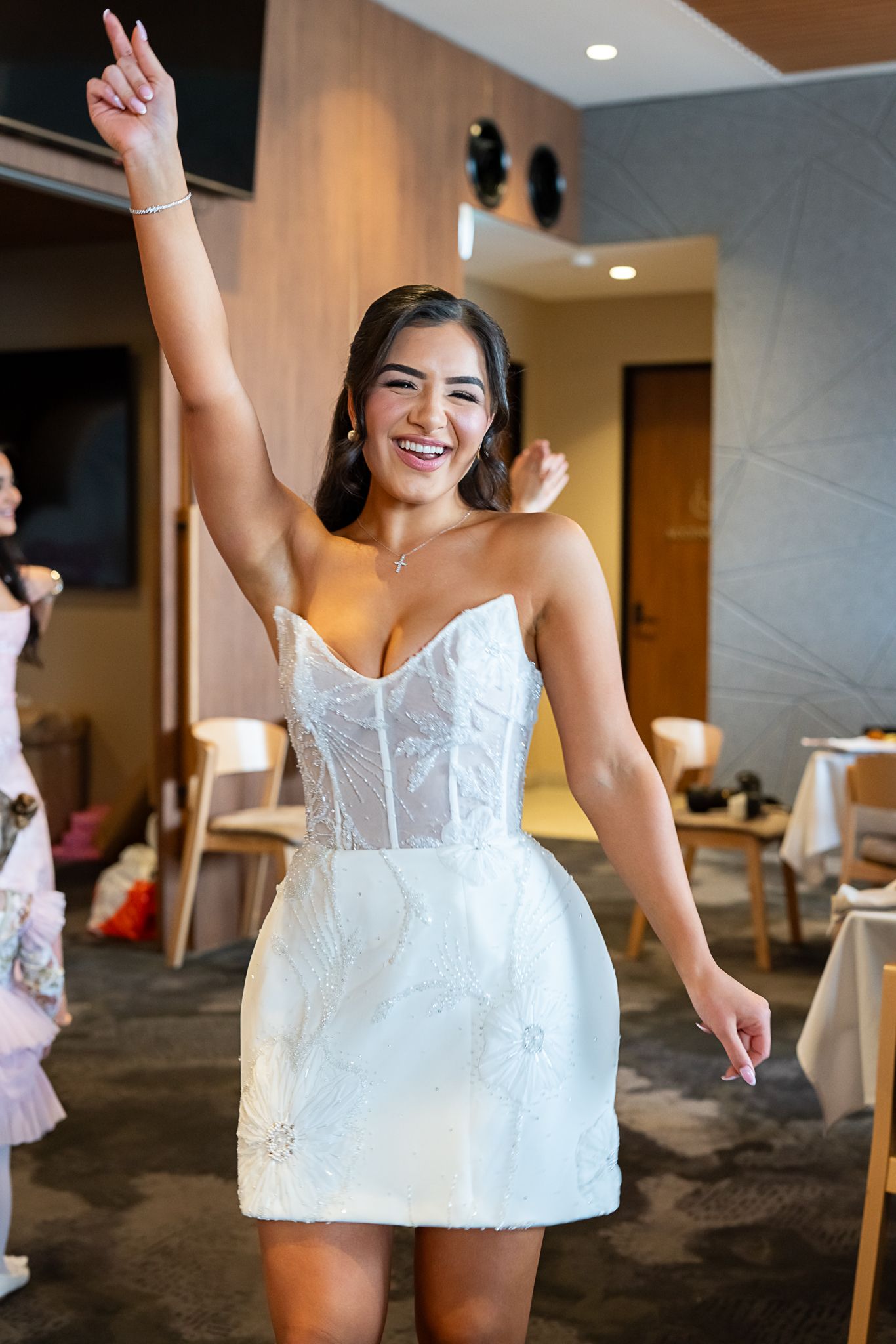 Elegant short white corseted dress being worn during a celebratory moment.