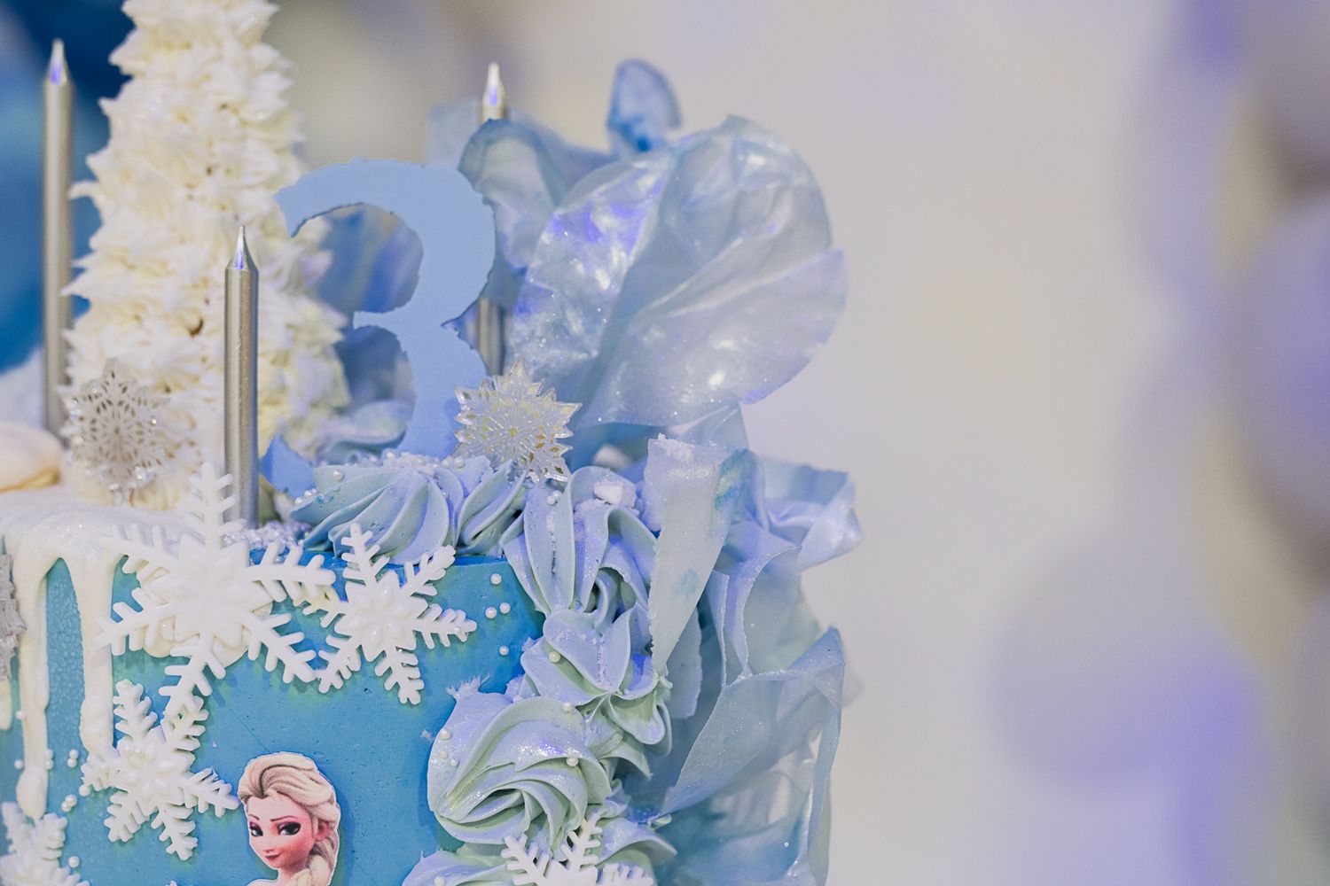 Detailed view of a winter cake showing intricate snowflake decorations and blue frosting details.