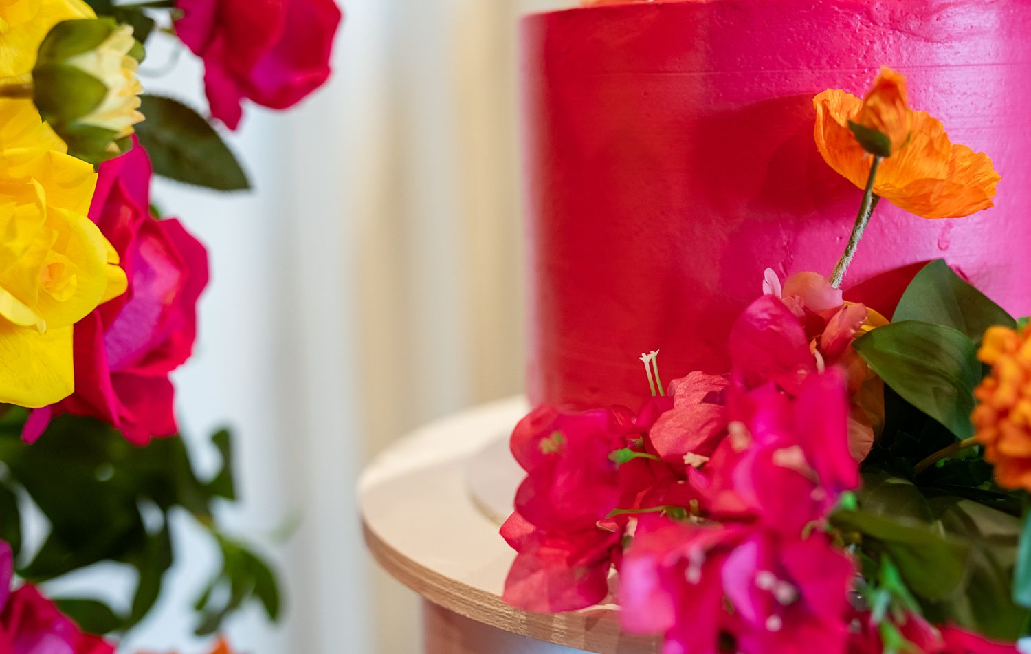 Bright pink and yellow flowers with hot pink decor elements in artistic arrangement.