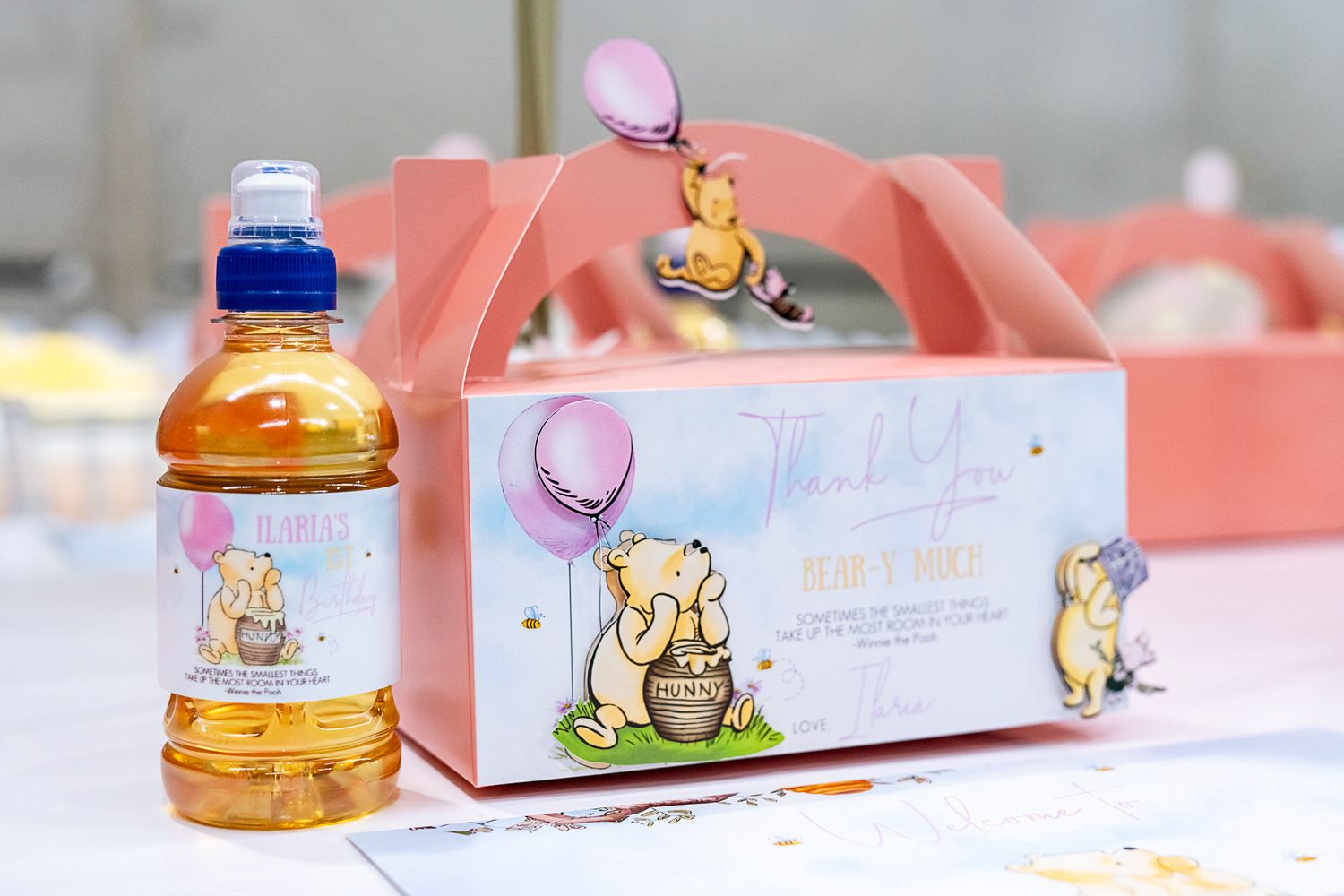 Winnie the Pooh themed party favor box and drink bottle with cute cartoon decorations.
