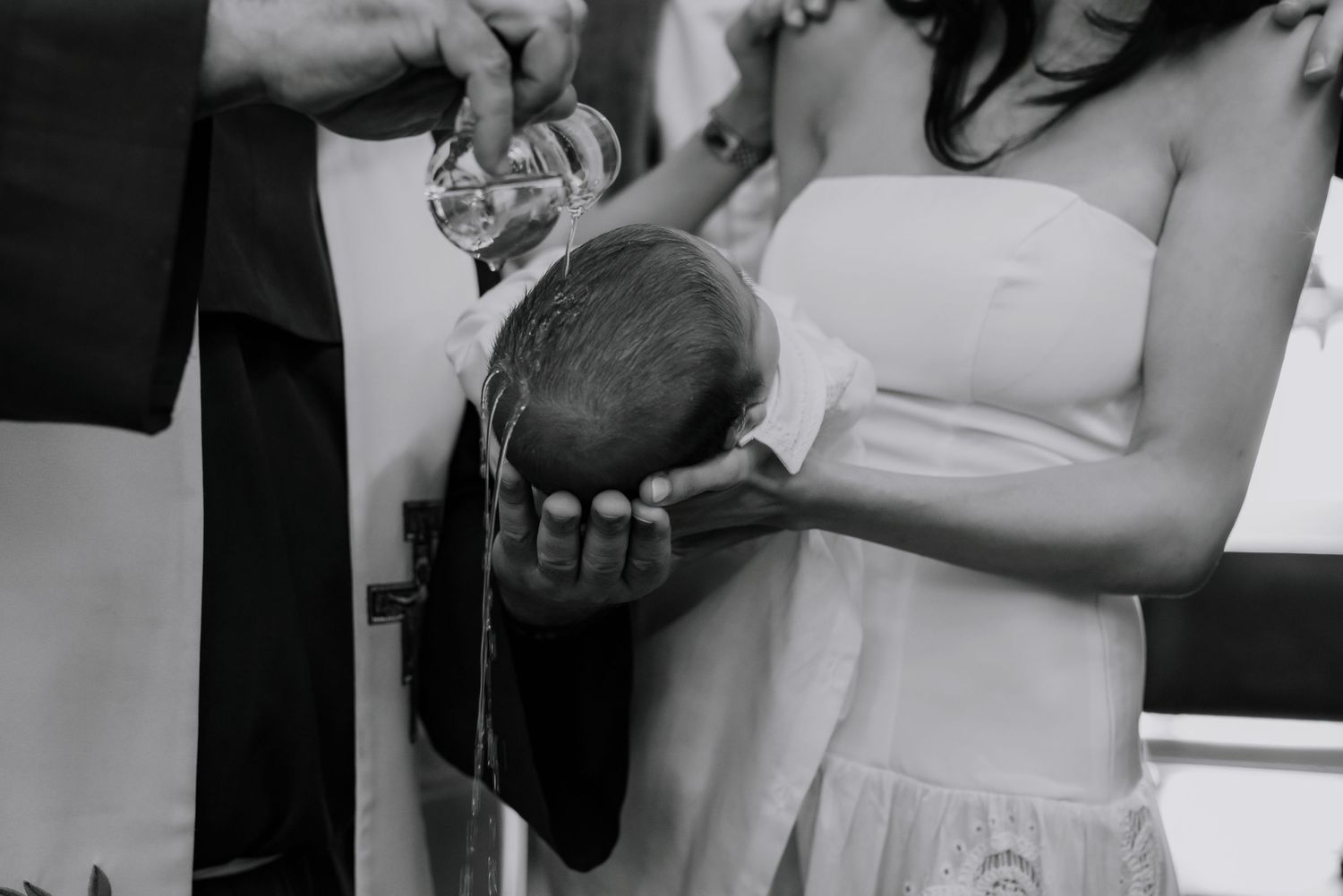 Black and white photo of baptism ceremony with water being poured.