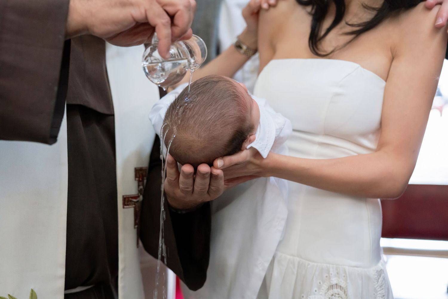 Ceremonial pouring of water over coconut during religious ritual.