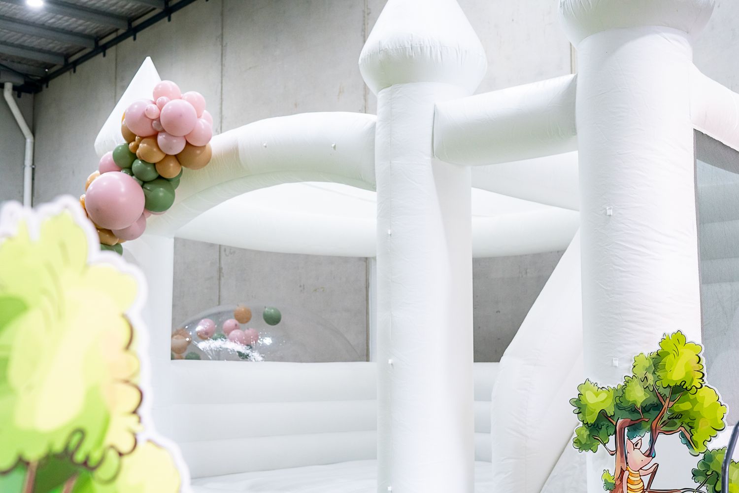 White inflatable structure with floral decorations against a gray wall.