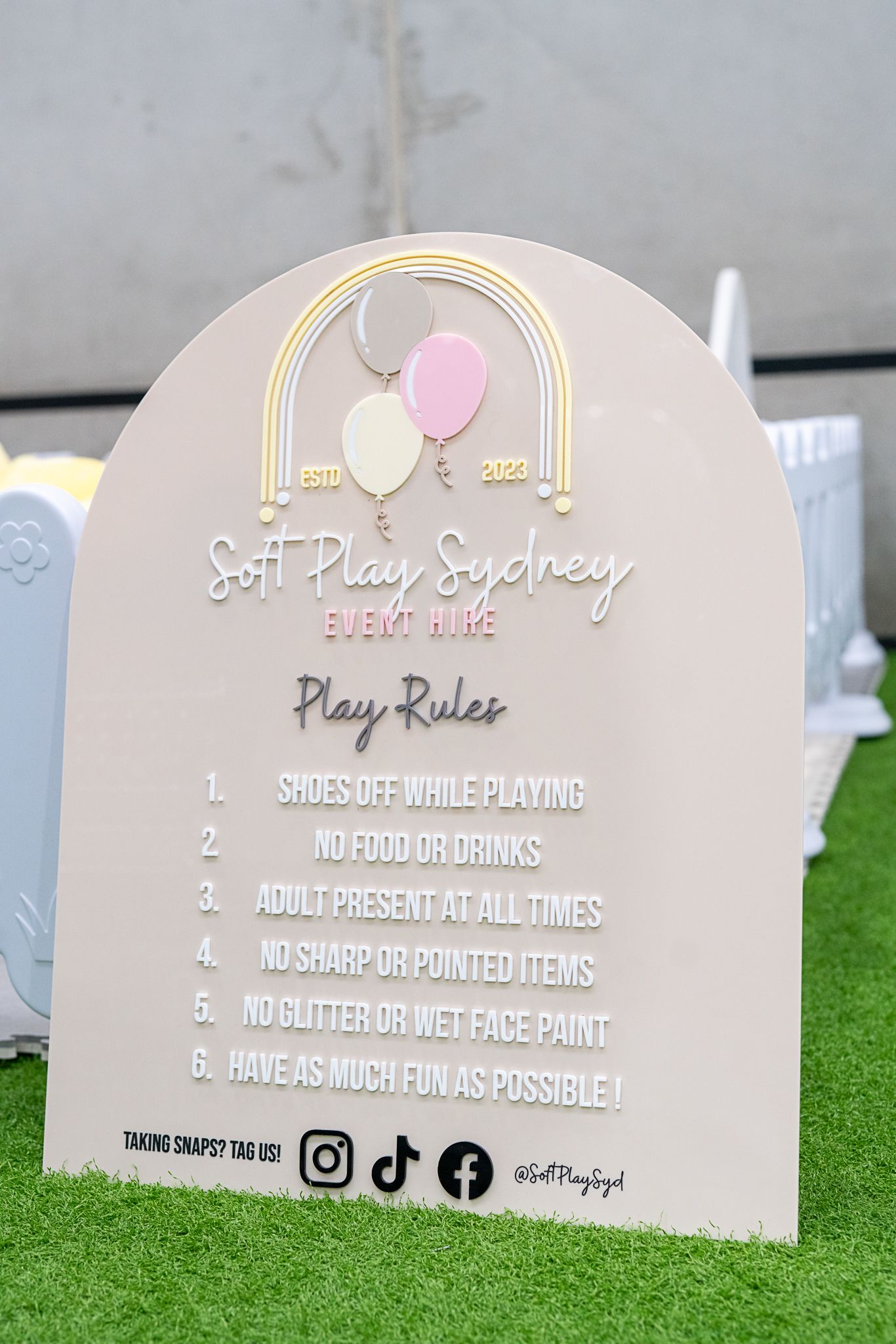 Play rules sign for soft play area with pink balloon design and social media handles.