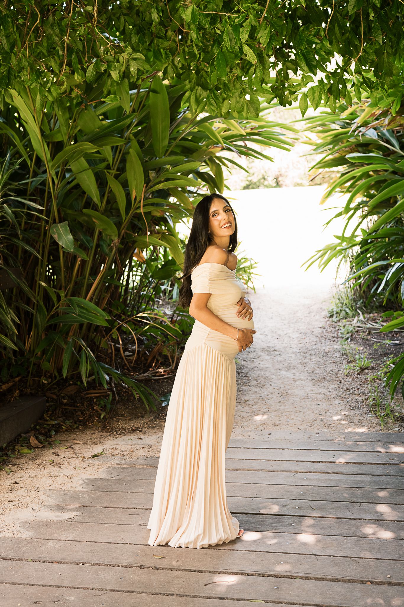Ethereal garden photo featuring a flowing cream-colored dress against lush tropical foliage.
