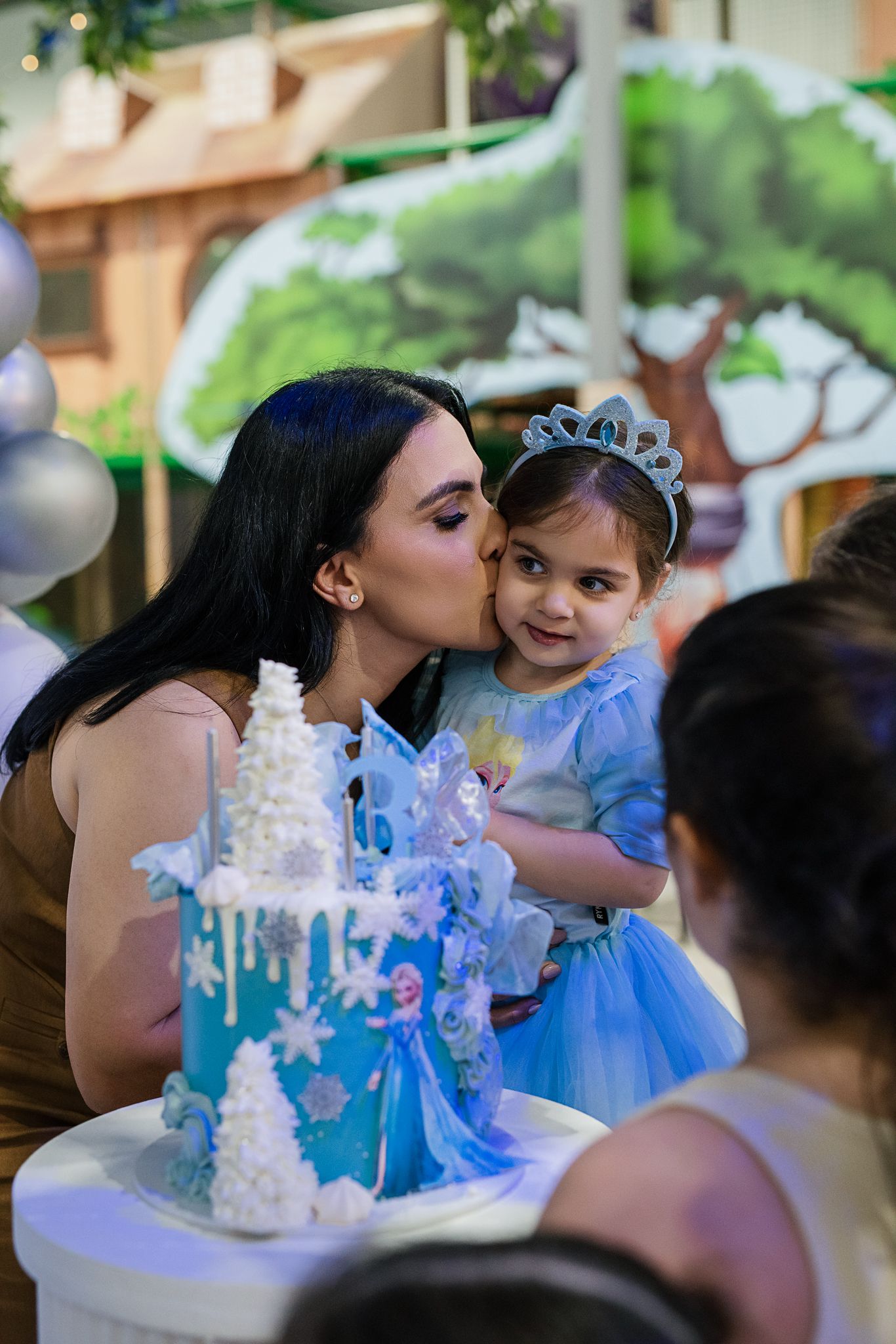 Festive winter-themed party setting with blue and white cake decorations.