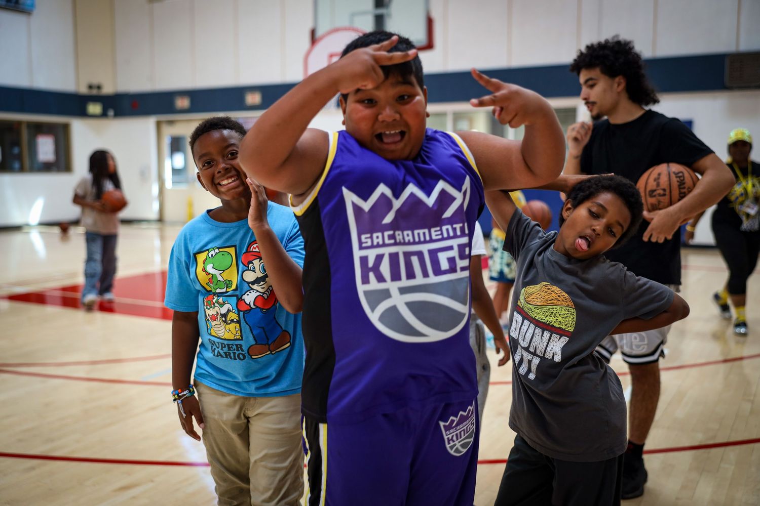 Basketball players practice drills and skills during an indoor training session at a community gym.