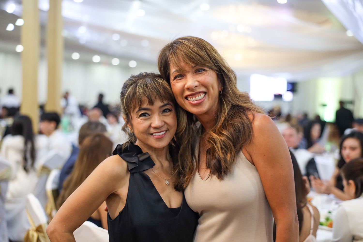 A group of friends enjoying a social gathering with smiles and laughter at an indoor event.