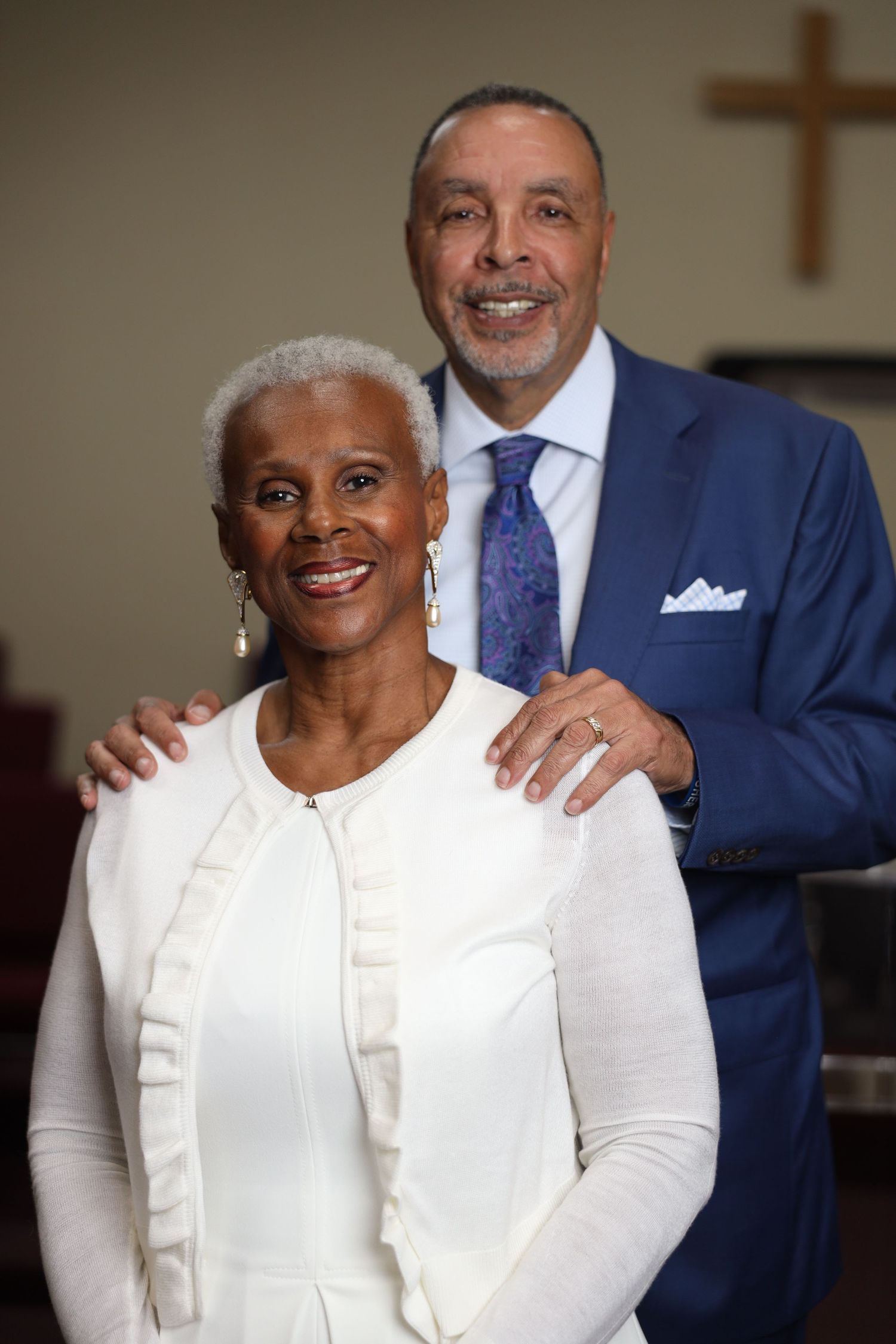 A series of similar photos showing two people in formal attire, one wearing white and one in navy blue, smiling together.