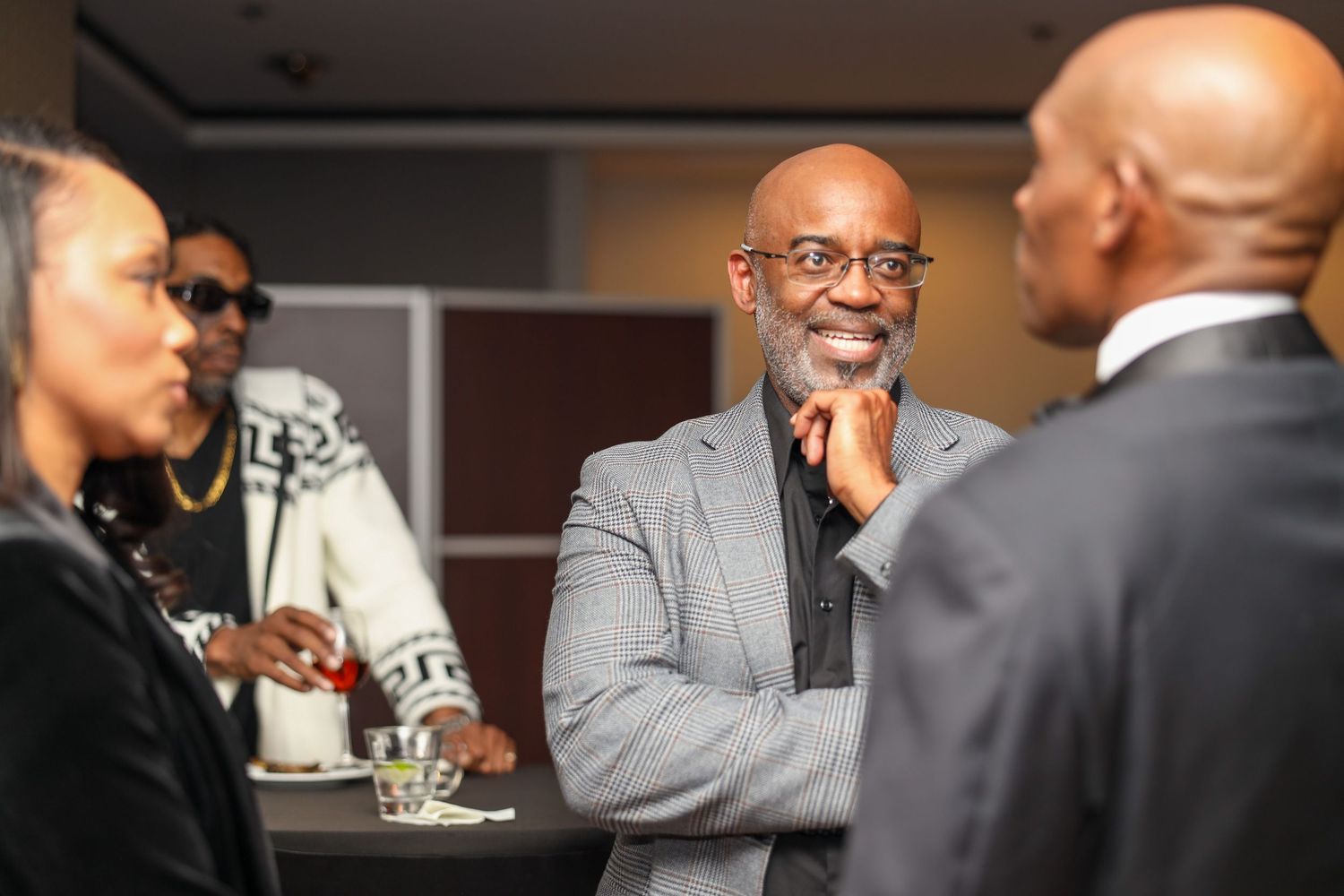 Business professionals engage in conversation during a networking event in a modern office setting.