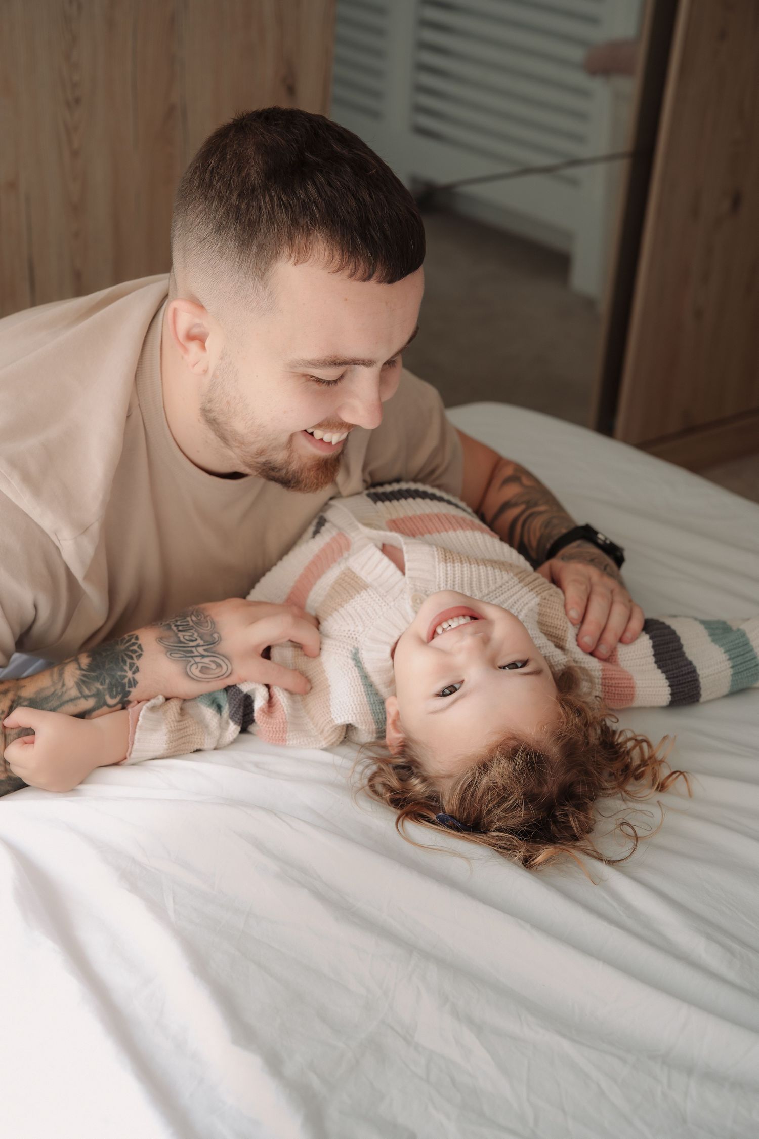 A series of four intimate photos showing tender moments between two people on white bedding.