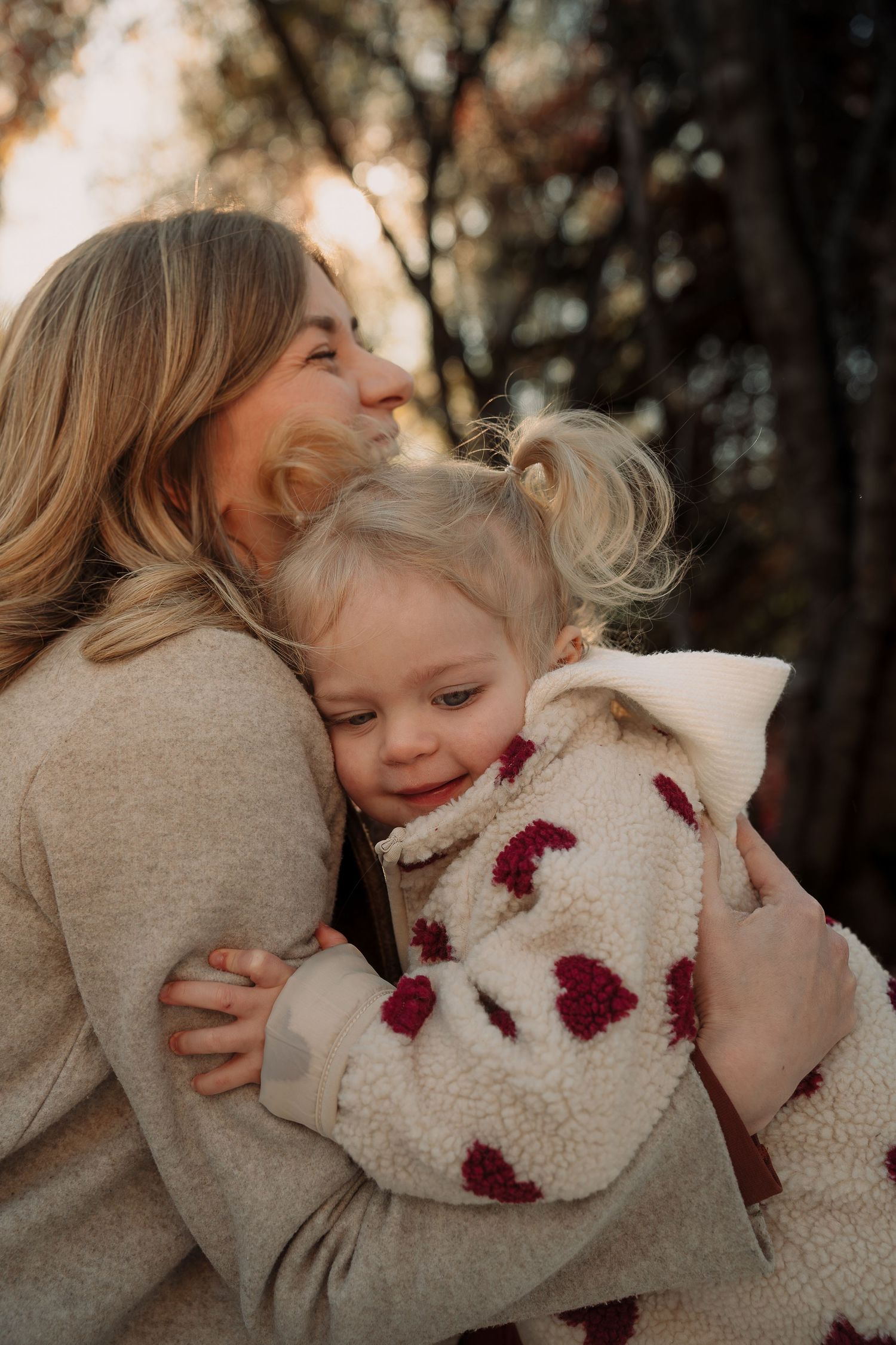 Tender family moment captured in warm autumn light with embraces and smiles.