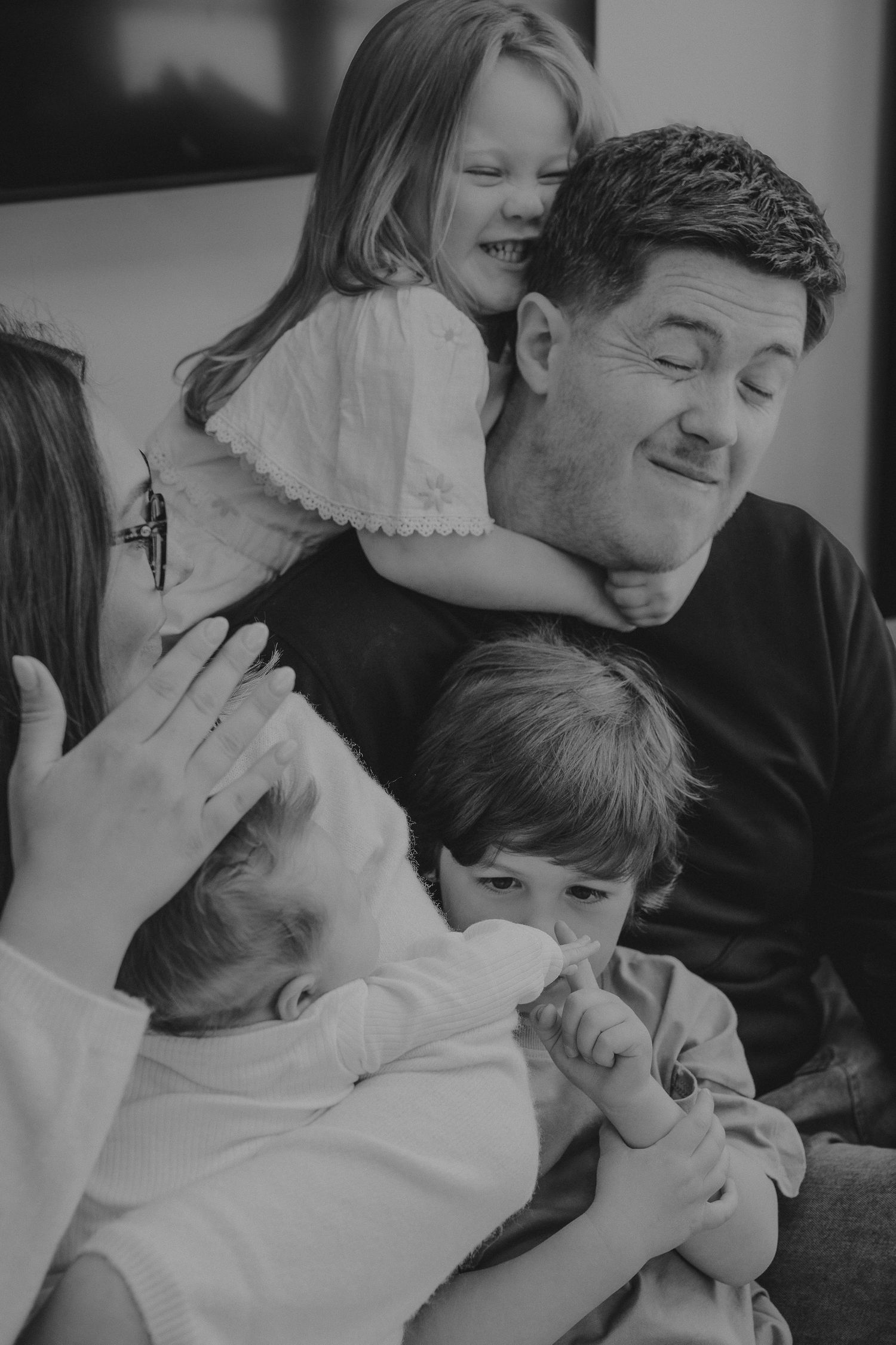 A heartwarming series of black and white family moments showing playful interaction and cuddles.