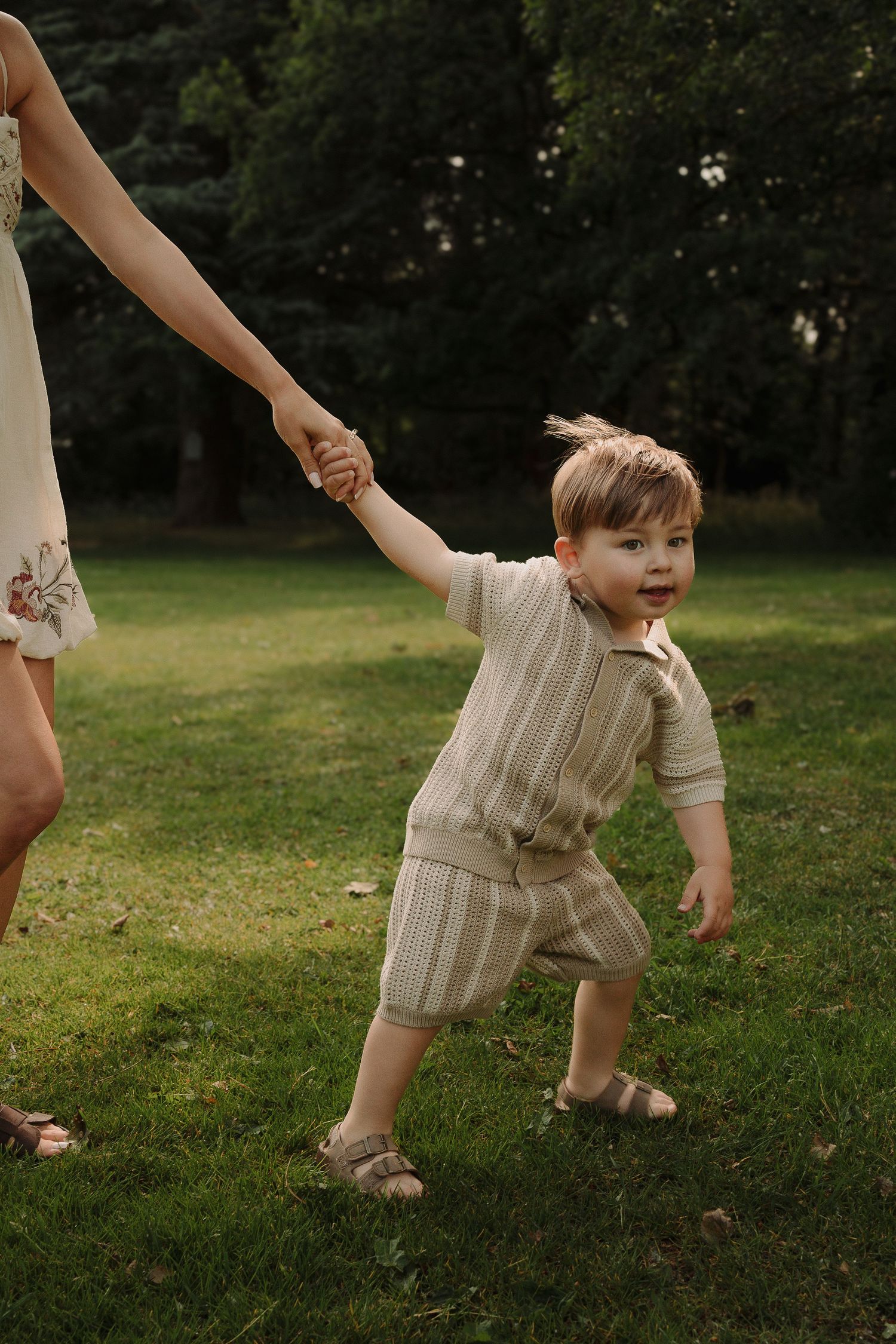 Playful moment showing a child being pulling mum in a grassy park during a Tamworth family session.