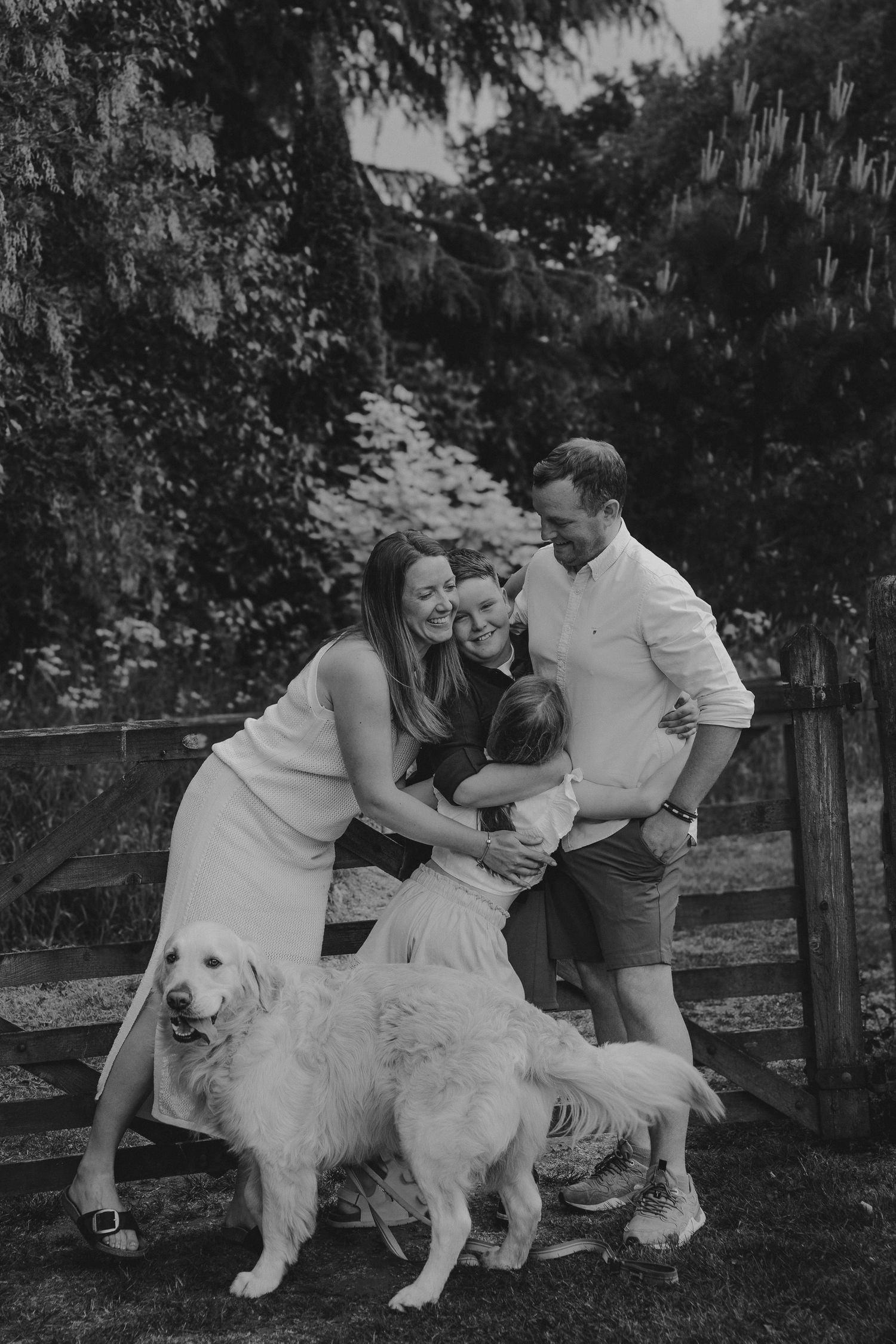 Playful outdoor scene with a large white fluffy dog being petted in a garden setting.