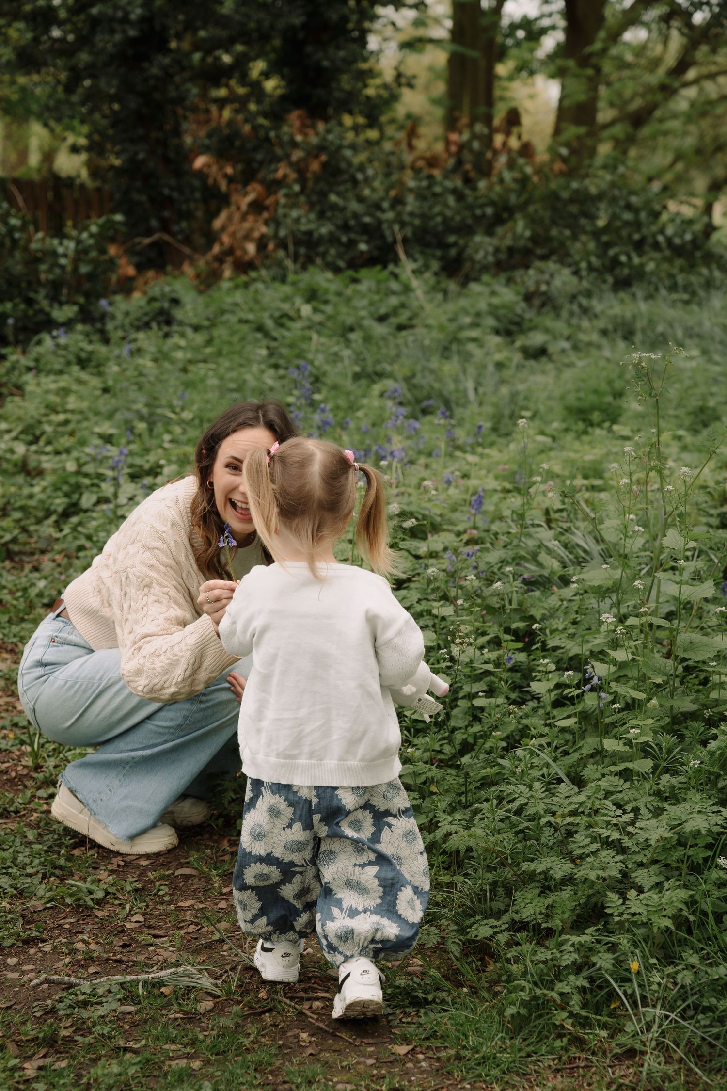 Two people sitting in a lush green garden setting sharing intimate moments in a series of candid photographs.