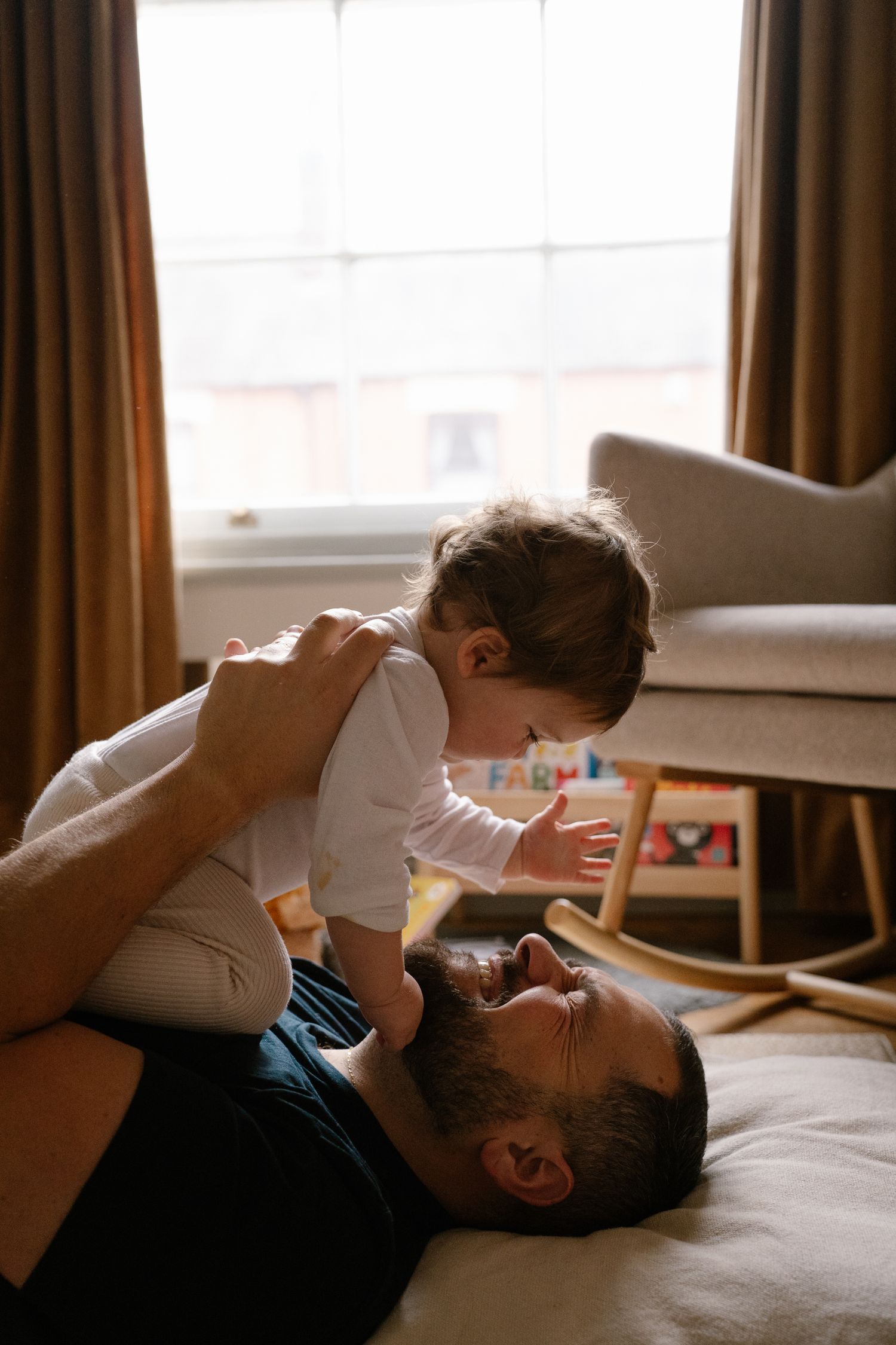 Intimate lifestyle photos capturing playful moments in a sunlit bedroom.