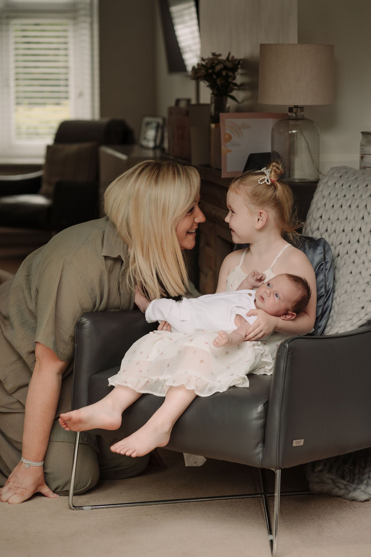 Tender lifestyle photography session in a modern living room with gray furniture.