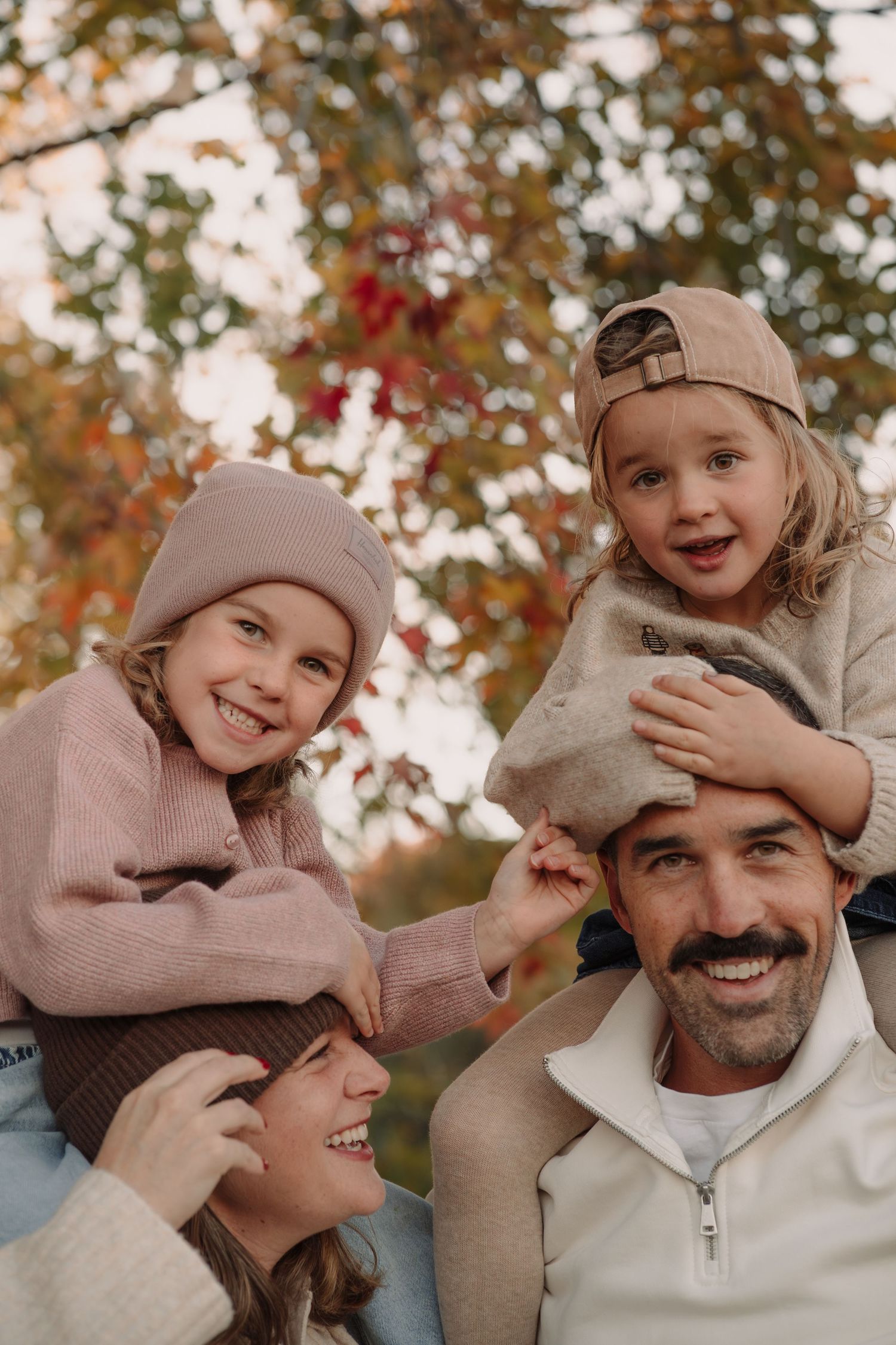 Candid autumn family photos showing joyful interaction against colorful fall foliage.