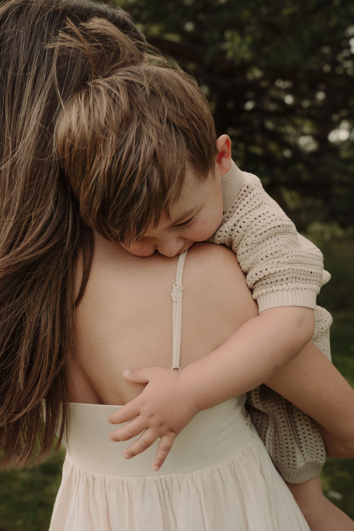 Close-up photo of mum and boy showing a tender embrace and hug in white summer clothing during Tamworth photoshoot.