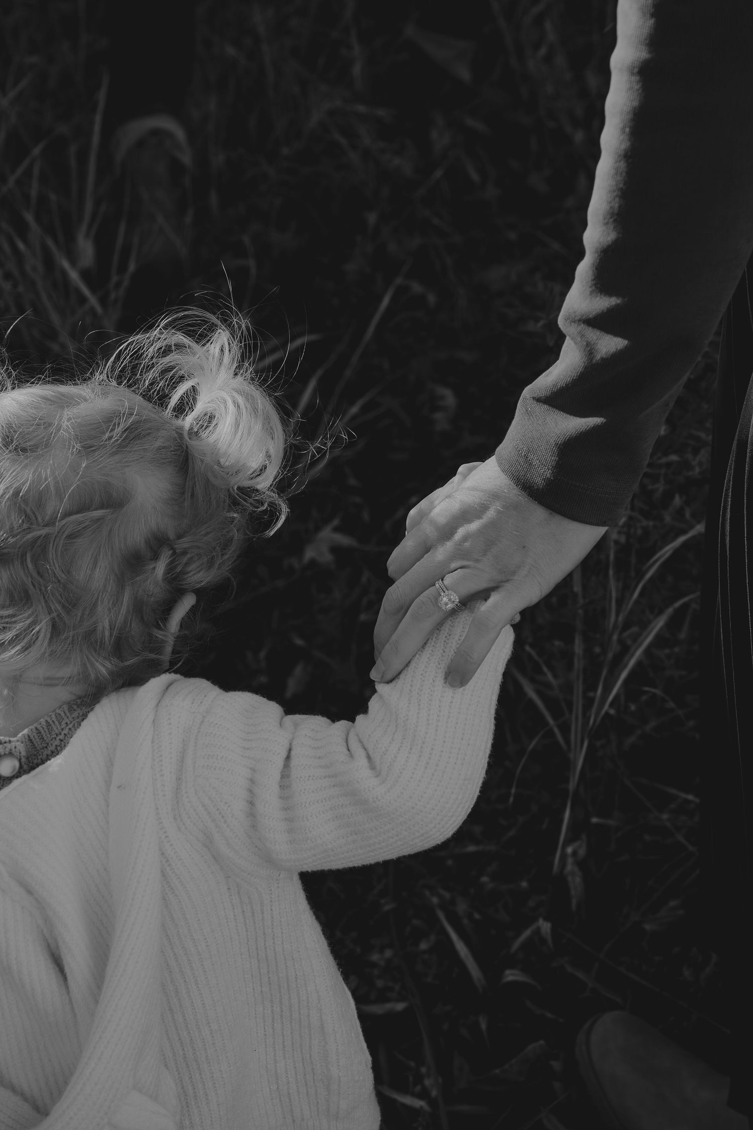 A sequence of black and white photos showing a person reaching up while wearing a white sweater.