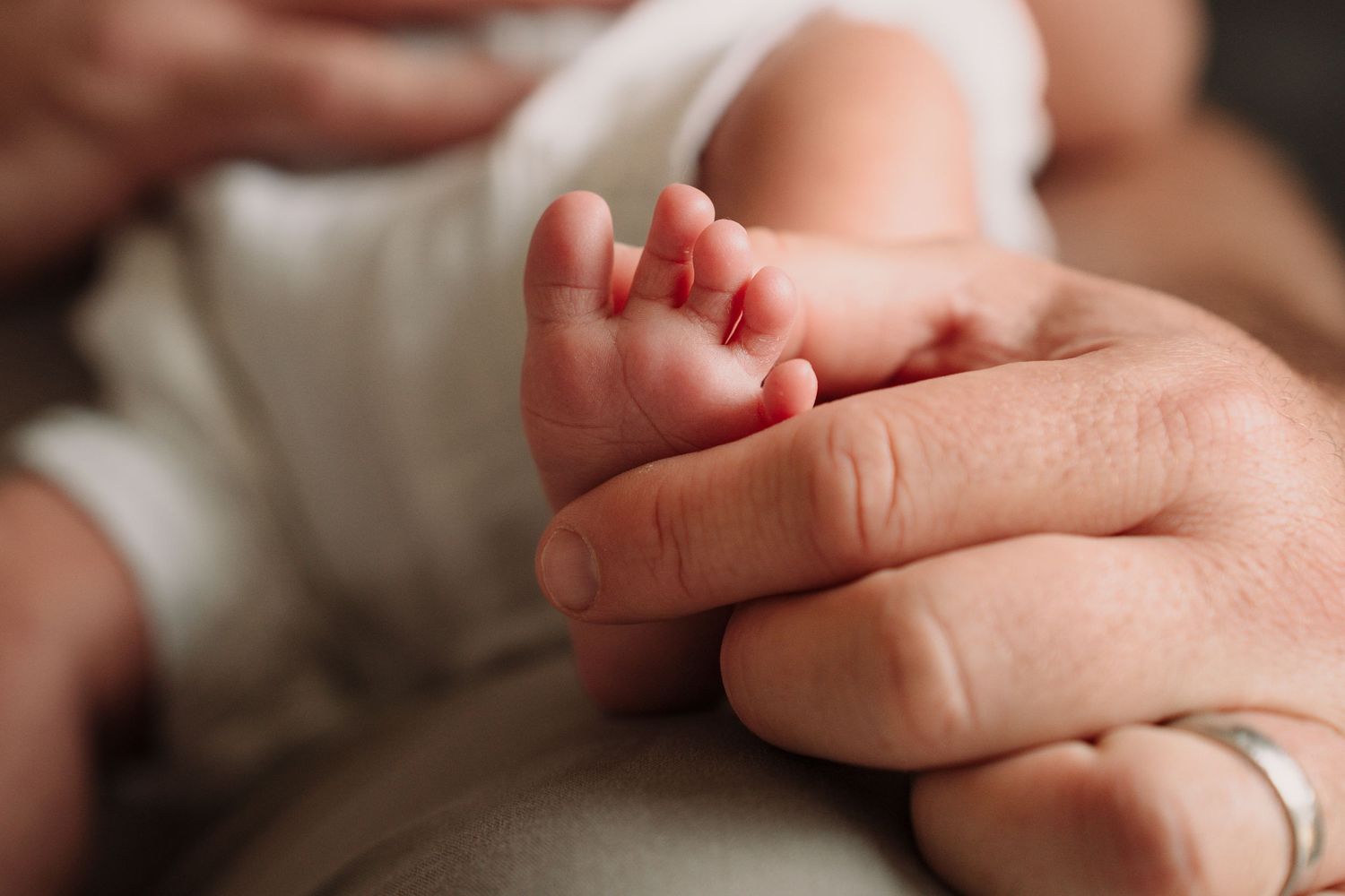 Close-up detail of tiny baby feet and gentle hands.