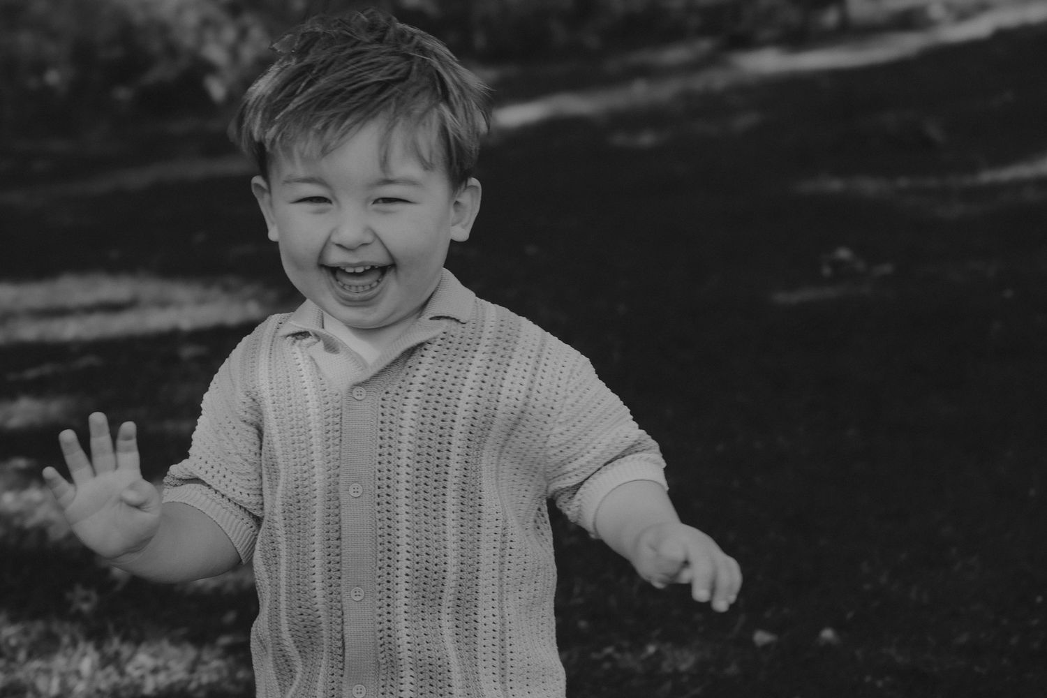 A series of black and white photographs showing joyful expressions and laughter in an outdoor setting during a Tamworth family session.