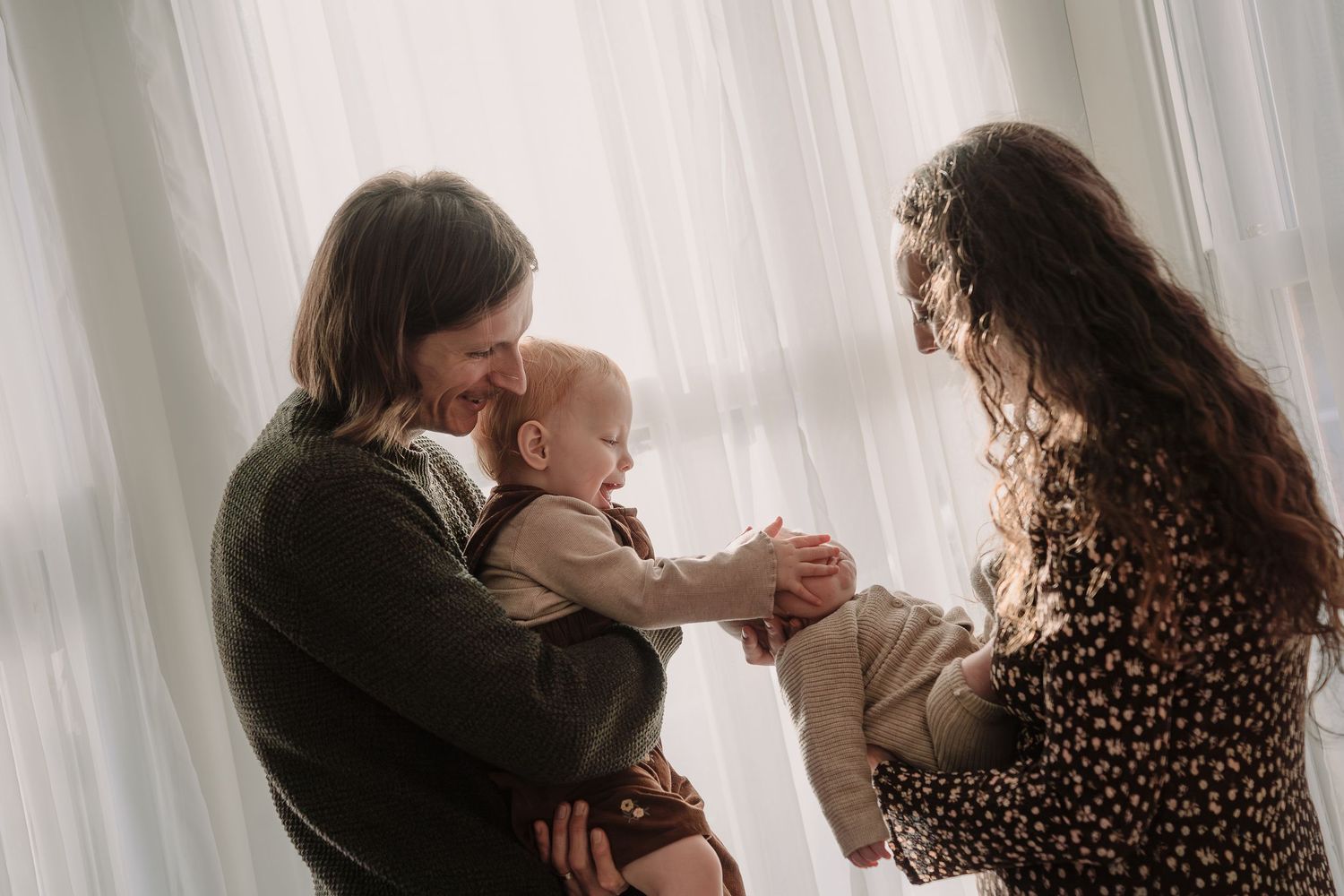 A tender moment captured in a series of intimate black and white photographs by a window.