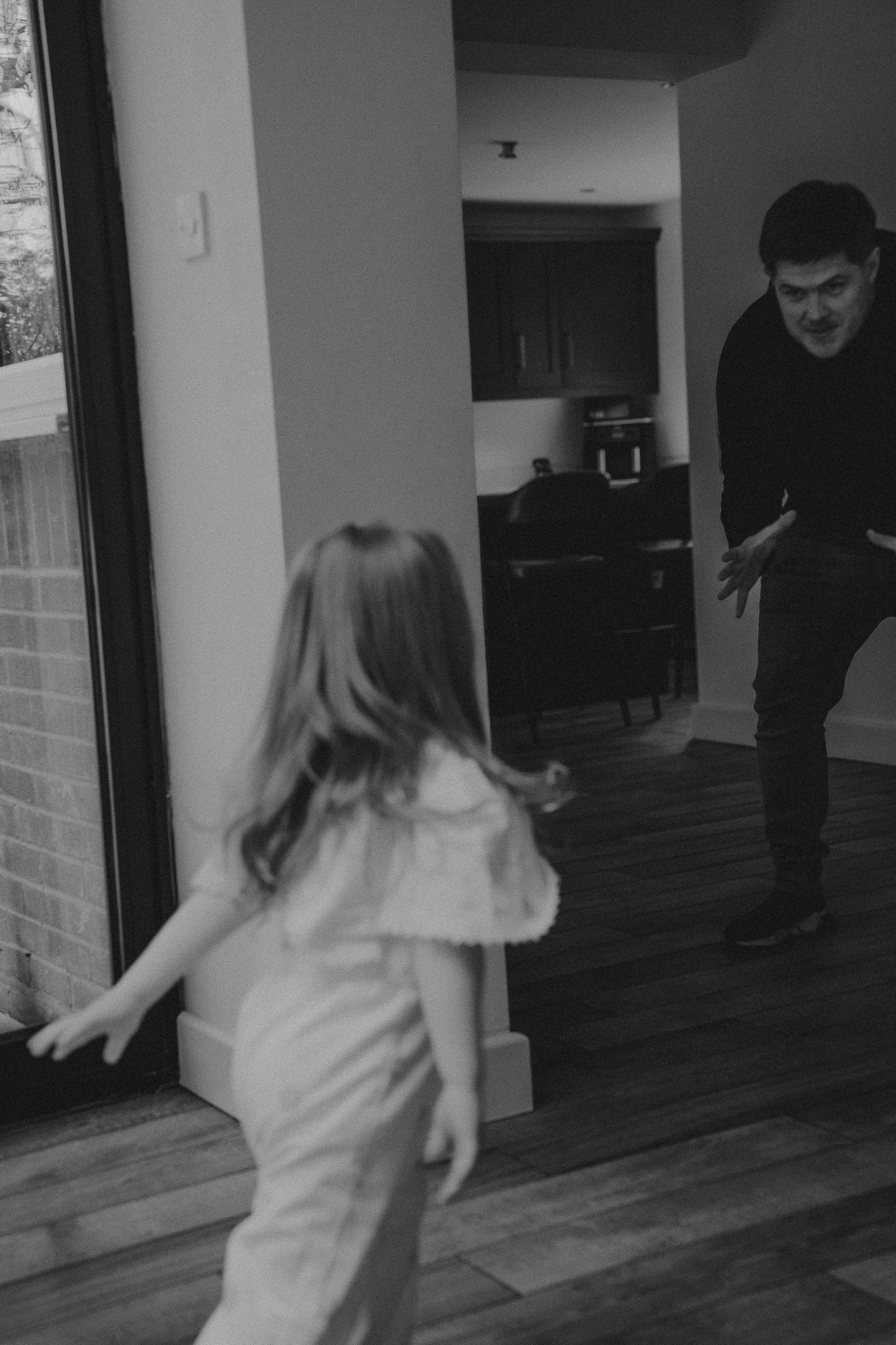 Black and white sequence showing playful movement and running through a modern home interior.