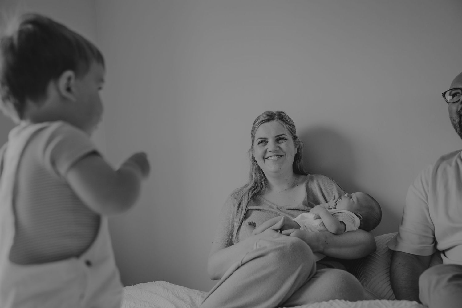 Black and white photo sequence showing tender moments between parent and newborn.