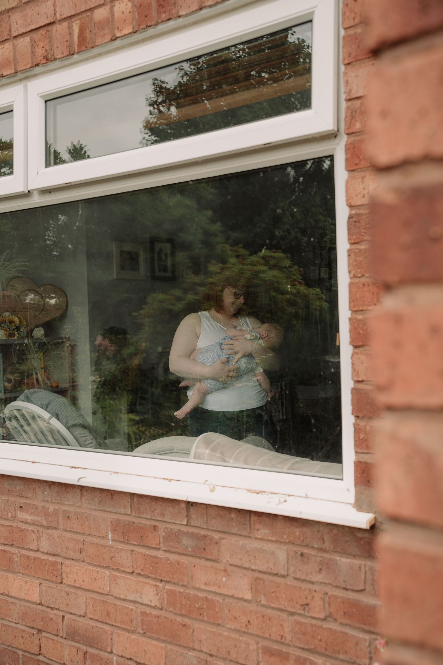 Series of window reflections in brick building showing interior scene.