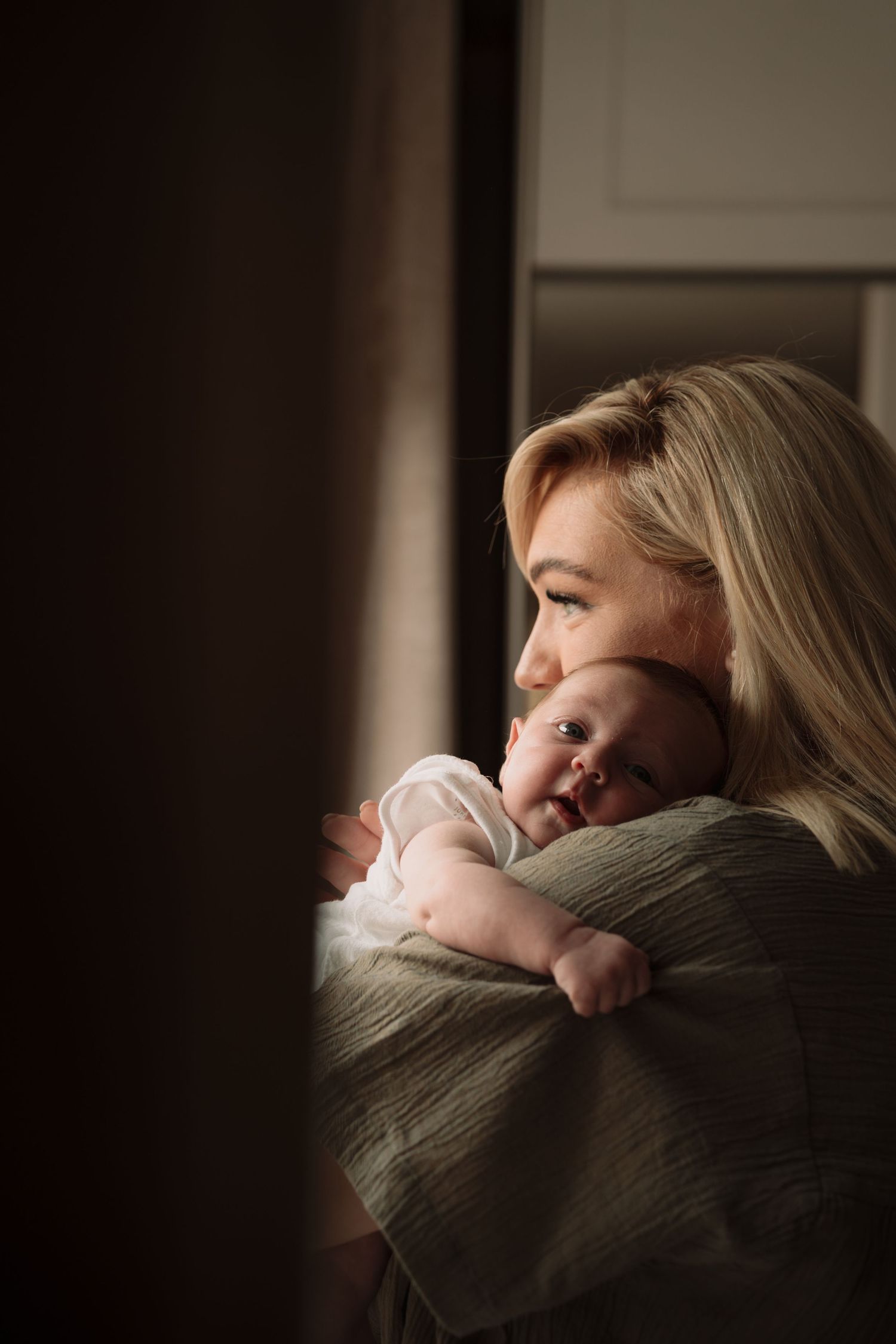 Intimate family portrait series in warm, moody lighting against dark background.