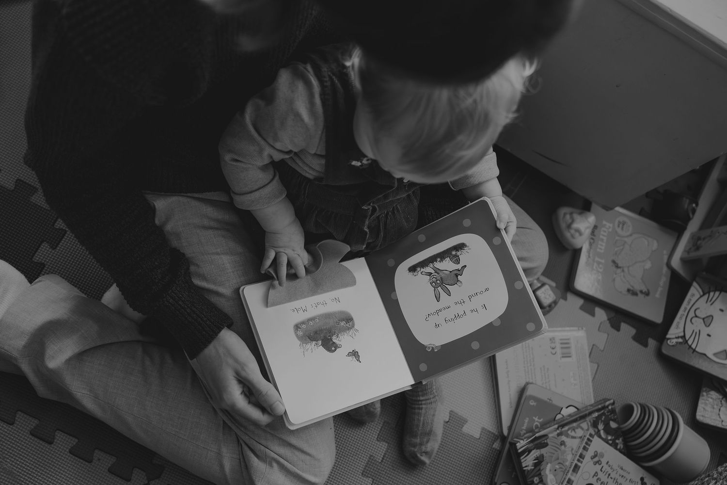 Overhead view of person looking through photo cards on dark surface.