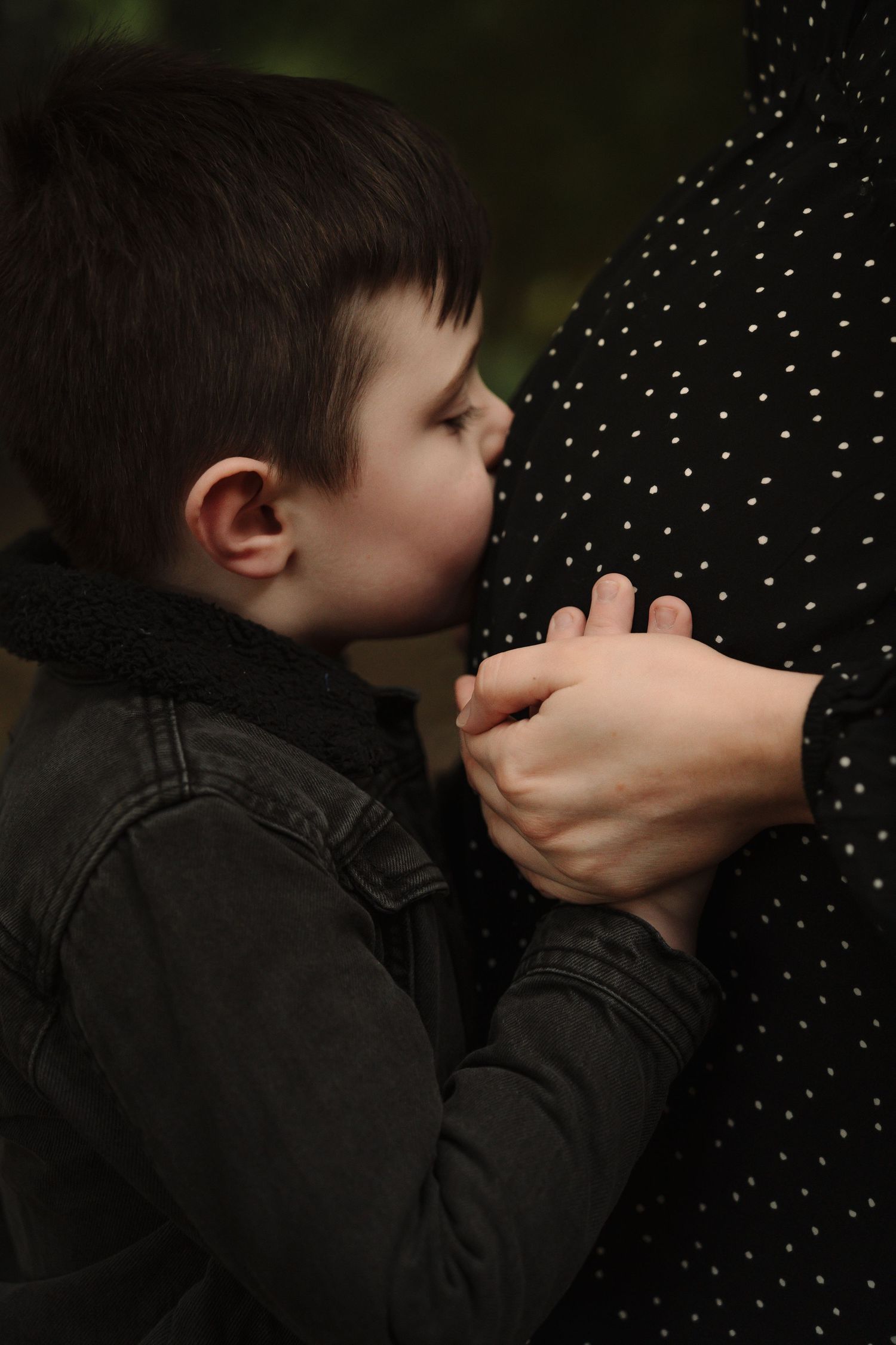 A person in a dark jacket stands against a dotted background in a series of sequential photos.