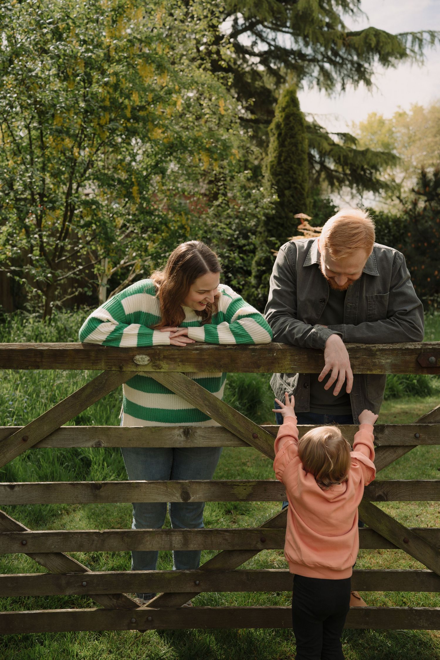 A sequence of photos shows a playful interaction between people leaning over a wooden fence in a garden setting.