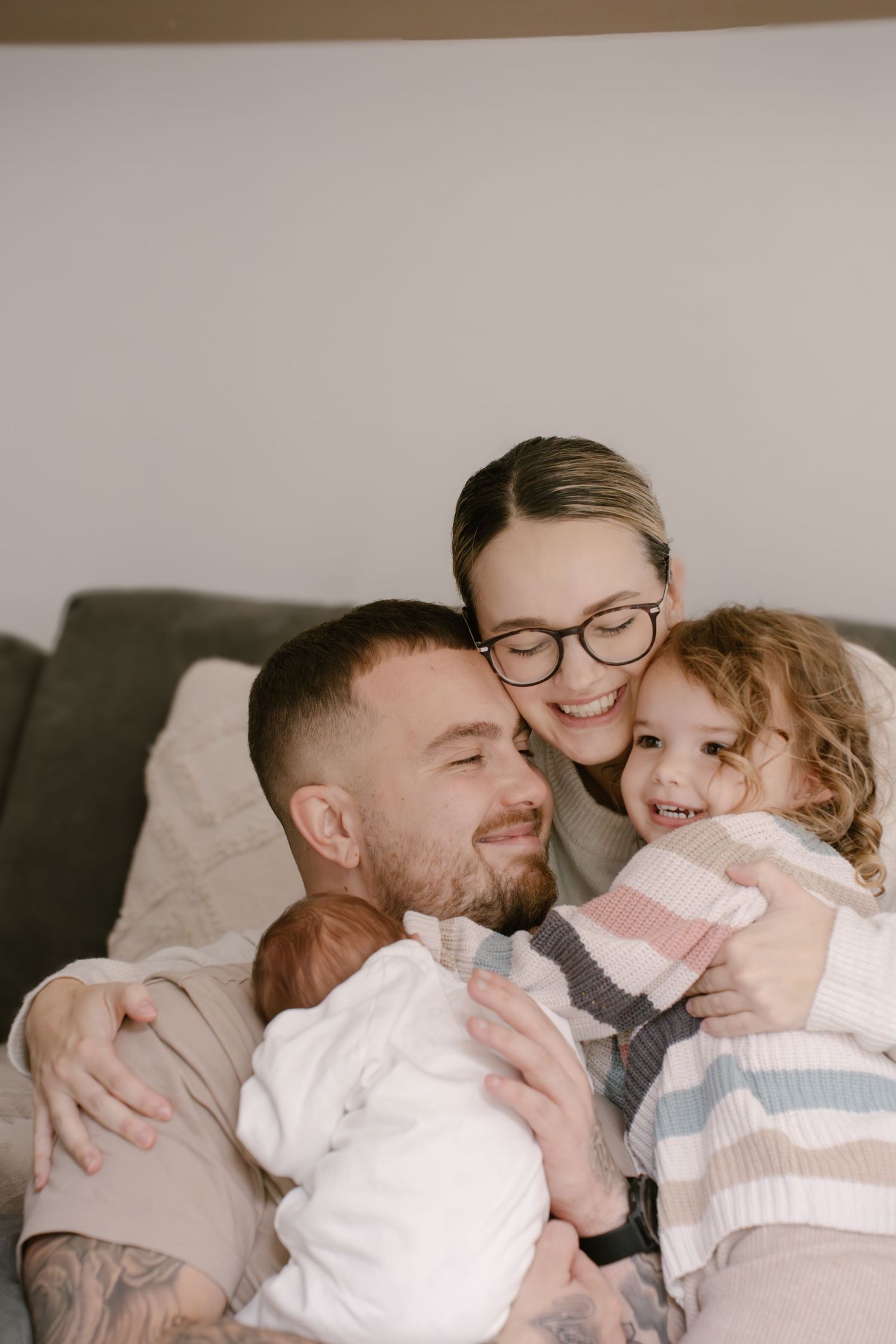 A series of tender family moments captured in five connected photos showing parents cuddling with their young child.